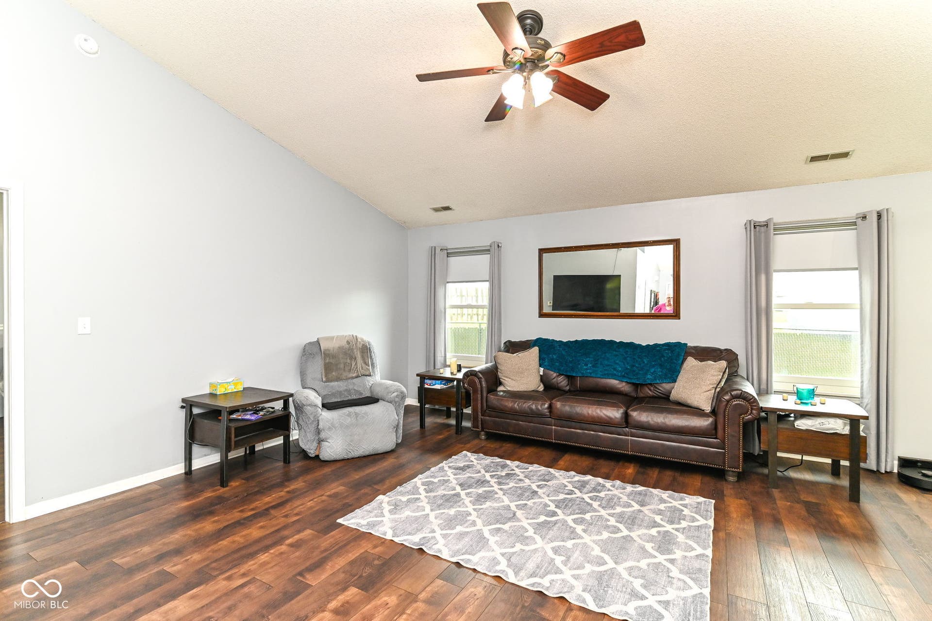 Vaulted ceiling with a ceiling fan, wood-finish flooring, and recessed lighting