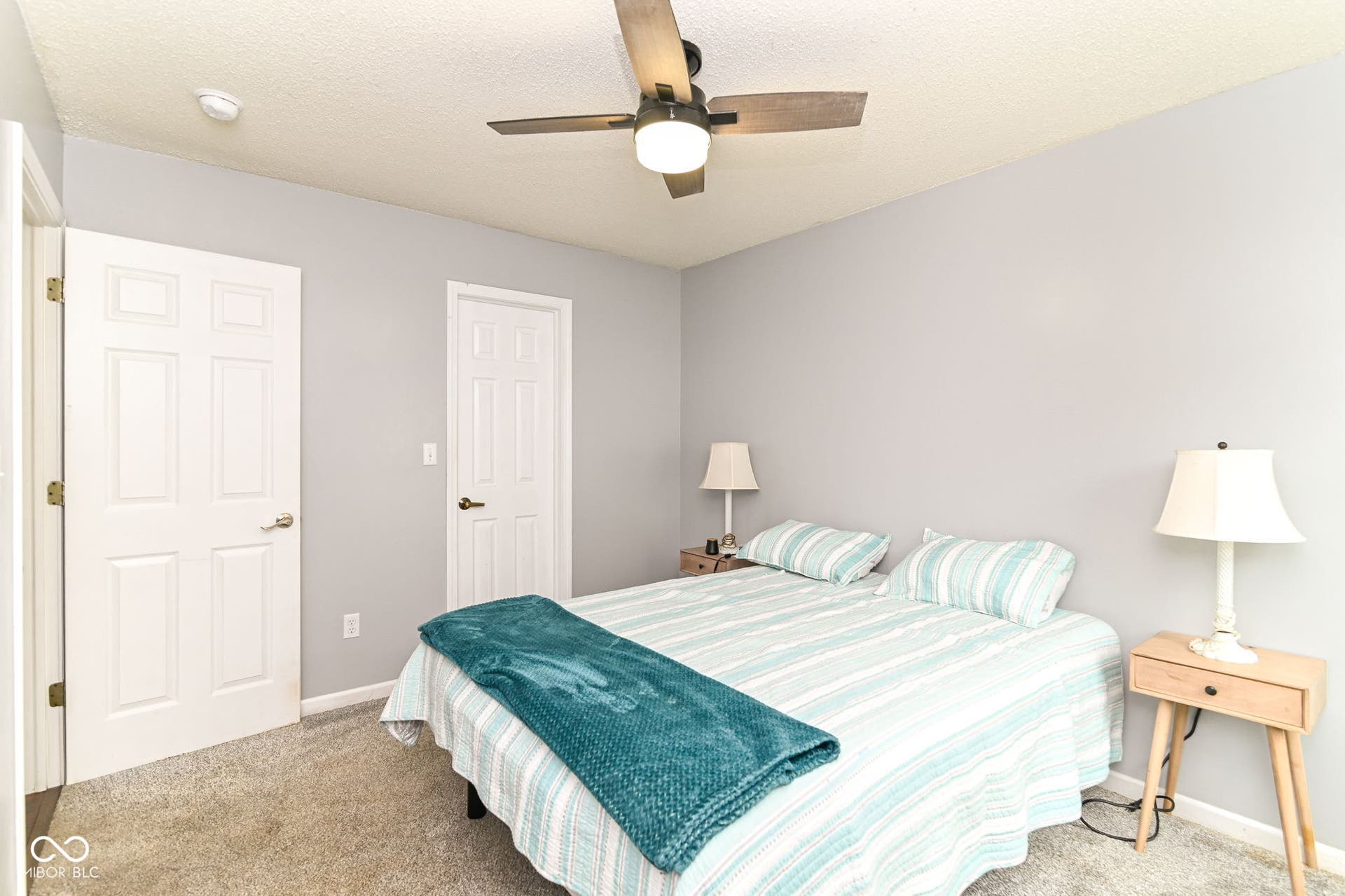 Carpeted flooring, ceiling fan with integrated lighting, and multiple paneled doors