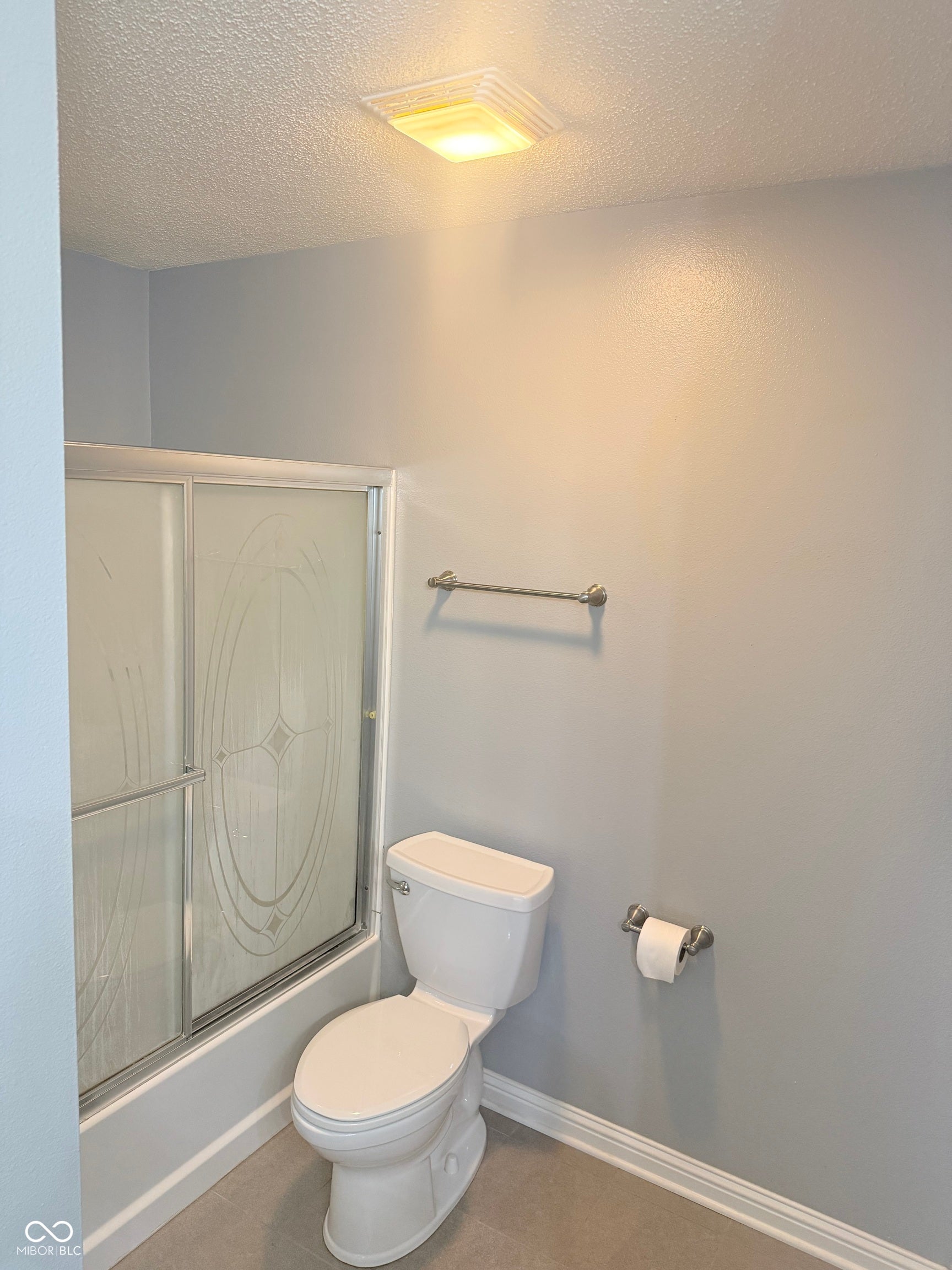 6235 E Mariah Hill Lane, Camby, IN 46113 Enclosed shower with sliding glass doors, white toilet, wall-mounted towel bar, and ceiling-mounted light fixture