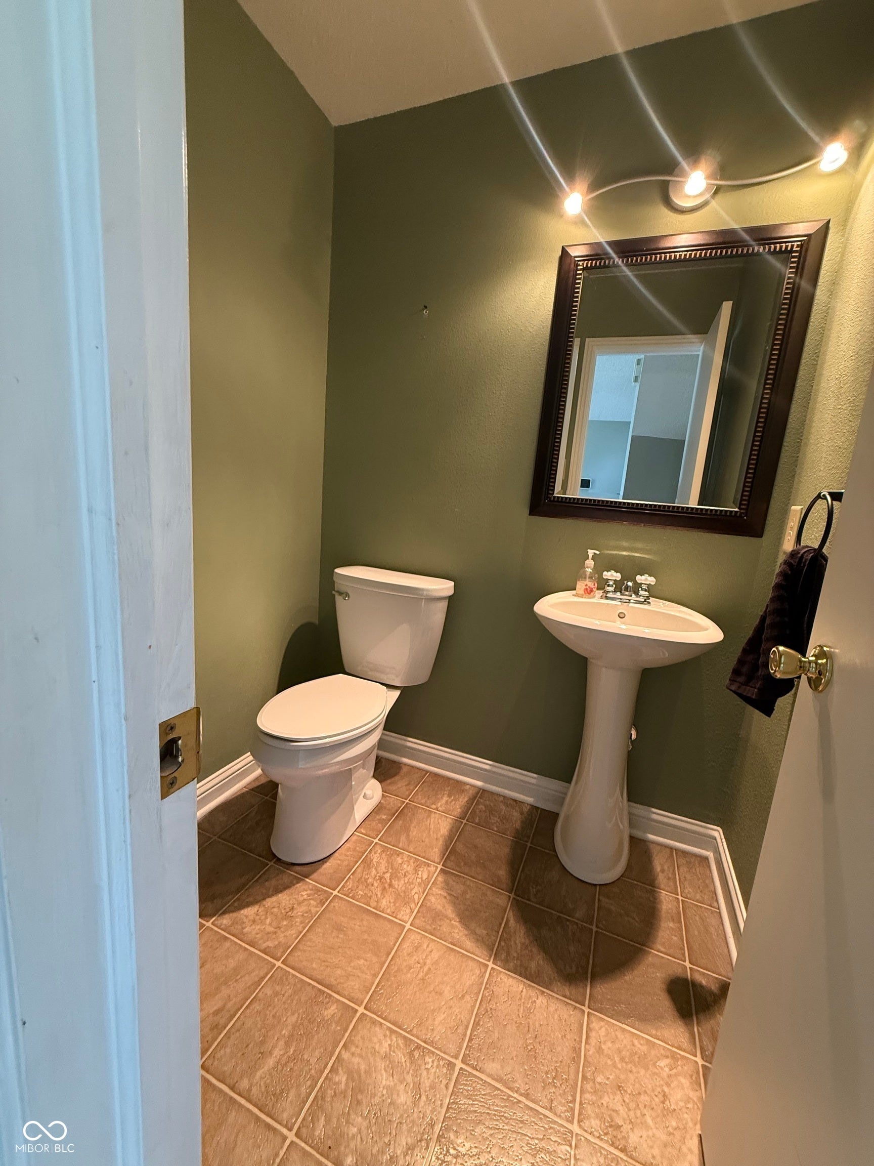 6235 E Mariah Hill Lane, Camby, IN 46113 Pedestal sink, ceramic tile flooring, and a decorative wall mirror