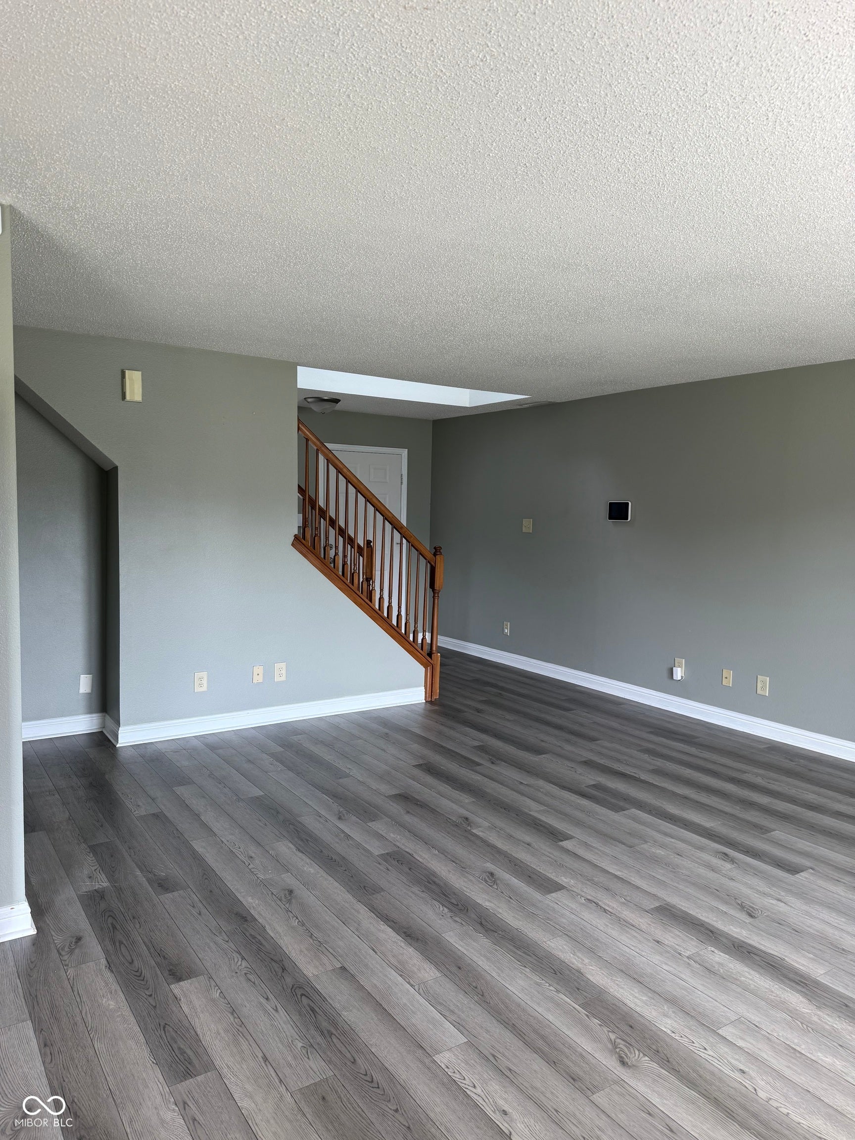 6235 E Mariah Hill Lane, Camby, IN 46113 Wood-finish flooring throughout, light gray wall color, white trim, and a wood staircase with white risers