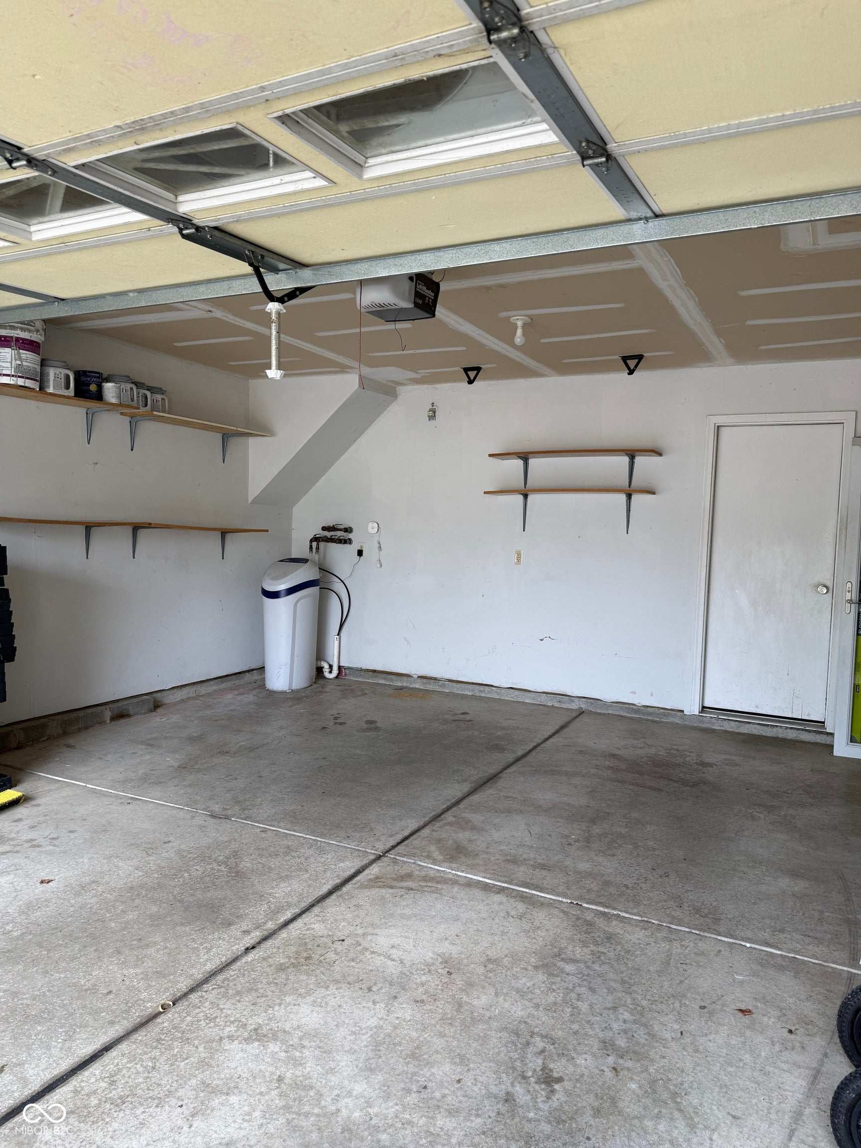 6235 E Mariah Hill Lane, Camby, IN 46113 Concrete flooring with built-in shelving and an overhead garage door