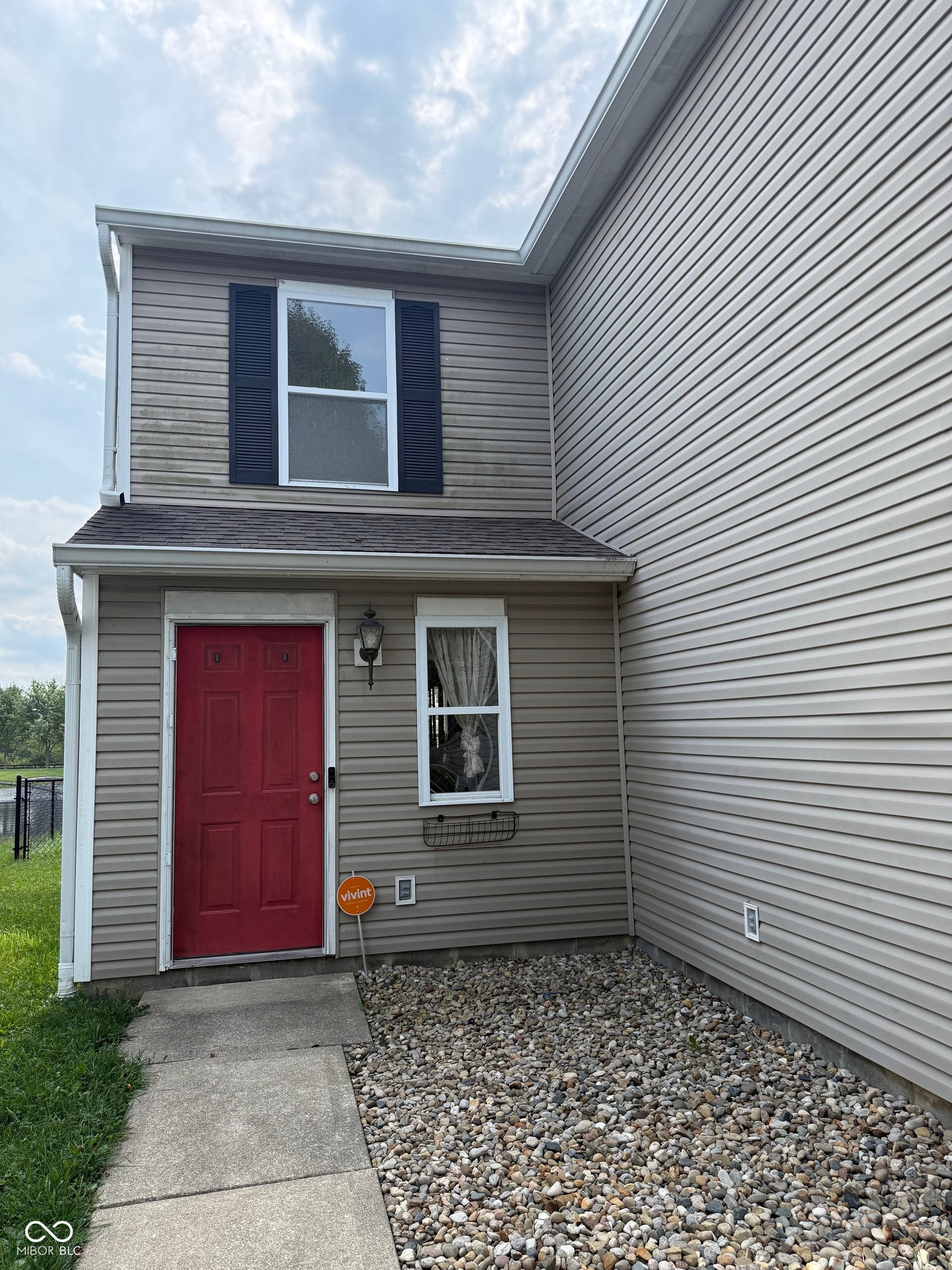 6235 E Mariah Hill Lane, Camby, IN 46113 Two-story exterior with horizontal siding, a red entry door, an exterior wall light, and a window with decorative shutters