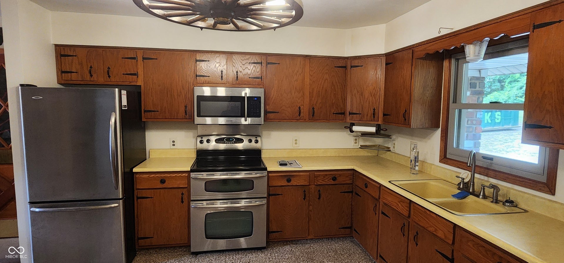Kitchen featuring wood cabinetry, stainless steel appliances, and a double basin sink