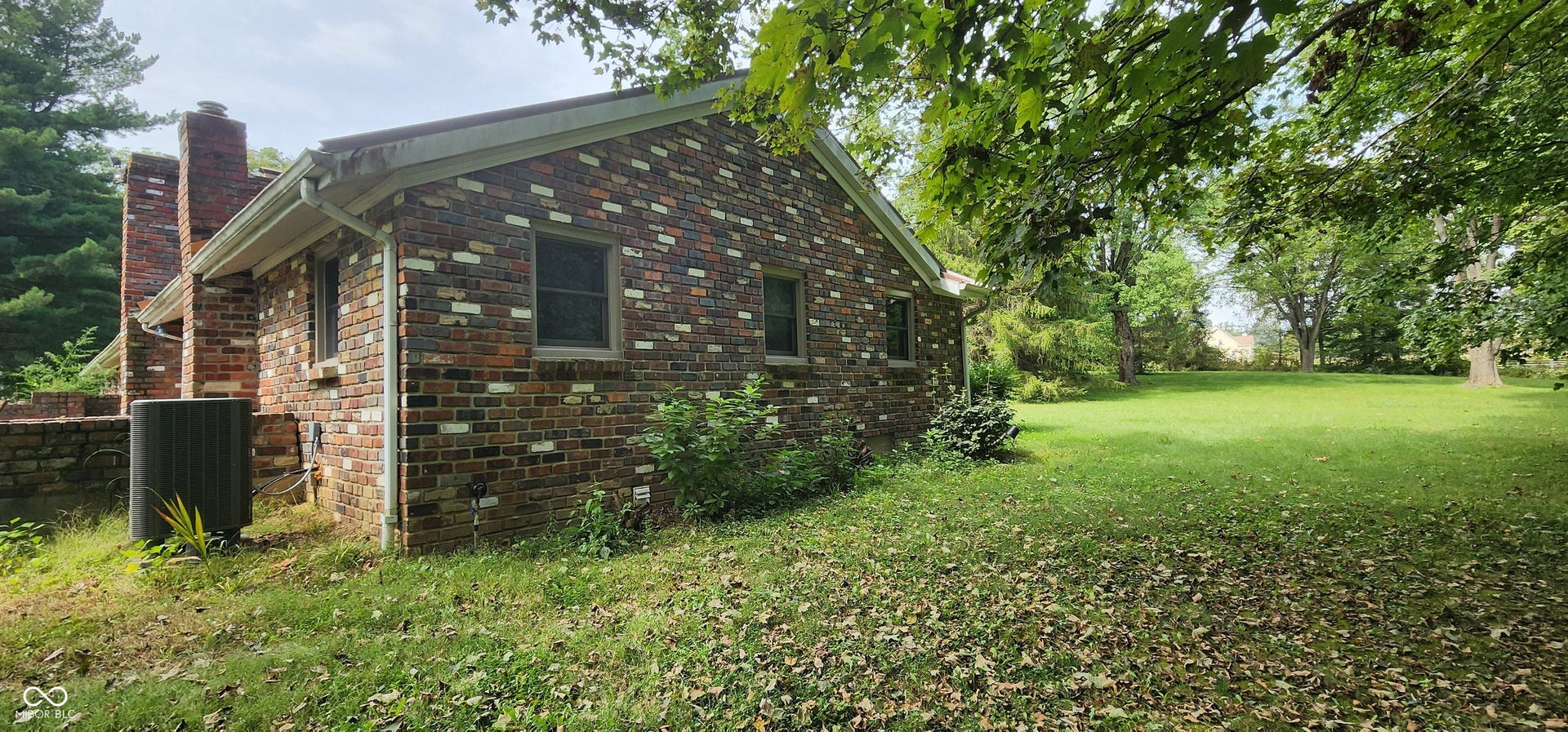 Brick exterior with multiple windows and a prominent chimney