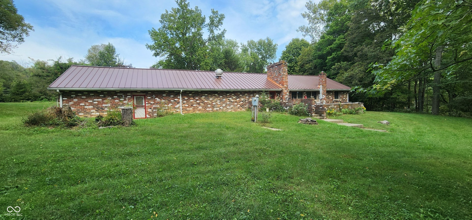 Brick exterior featuring a metal roof