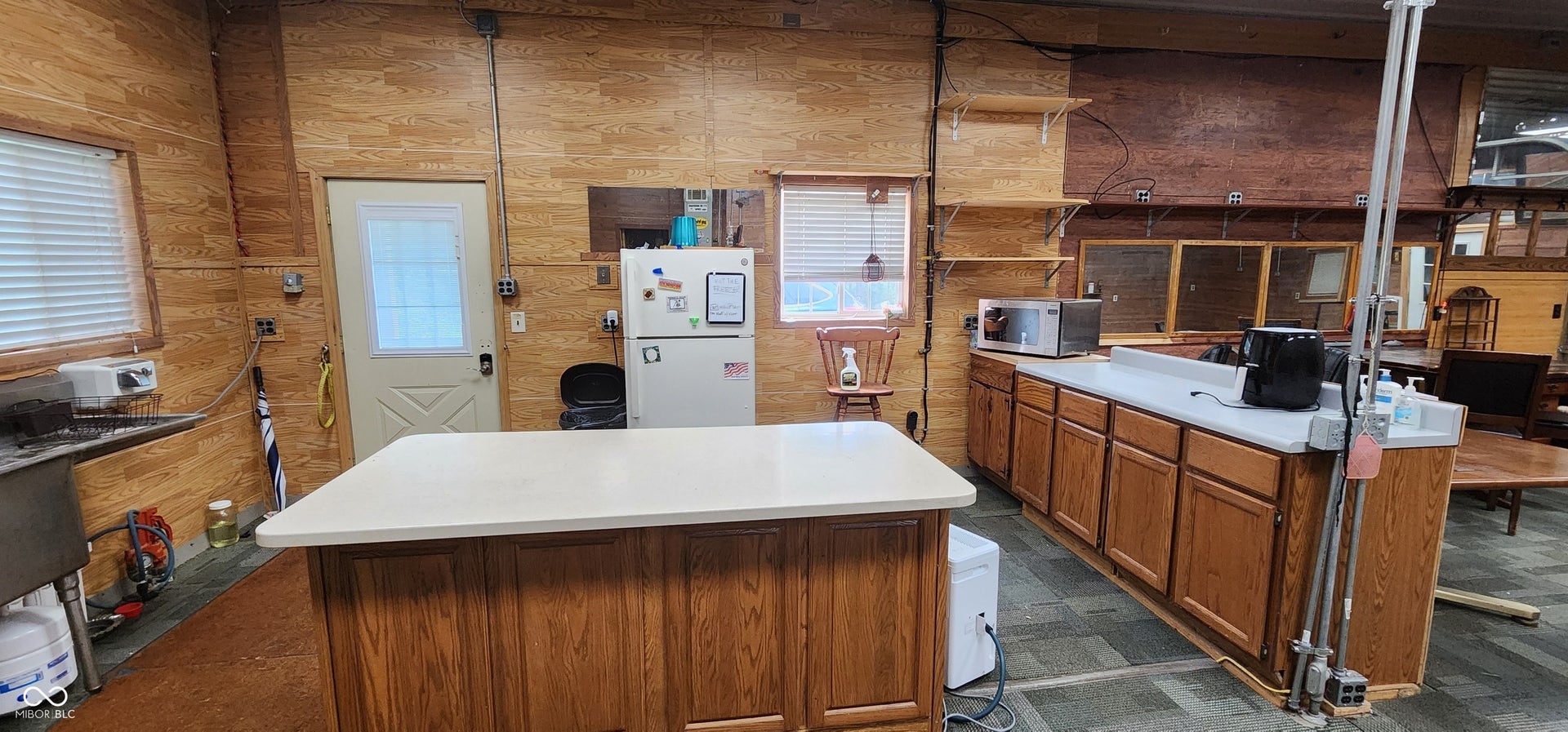 Wood-paneled walls with multiple windows and a door with a glass insert