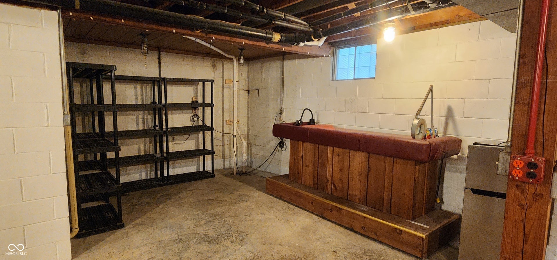Concrete flooring with exposed ceiling joists and bathroom extraction utility piping