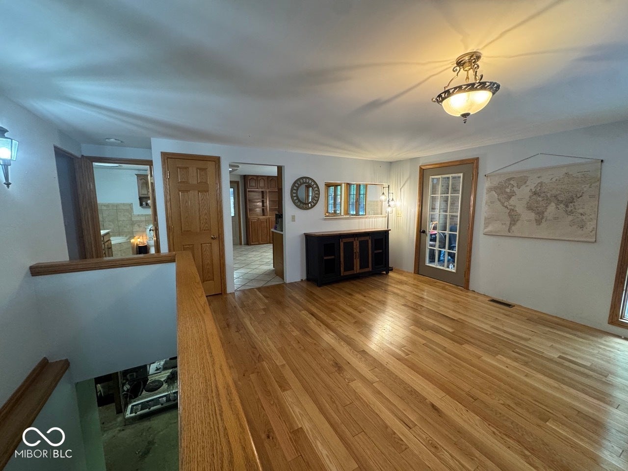 Hardwood flooring, painted walls, French-style door, and overhead lighting