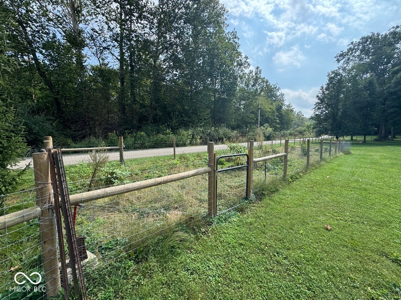 Expansive garden space featuring a wood and wire fence, and a gate