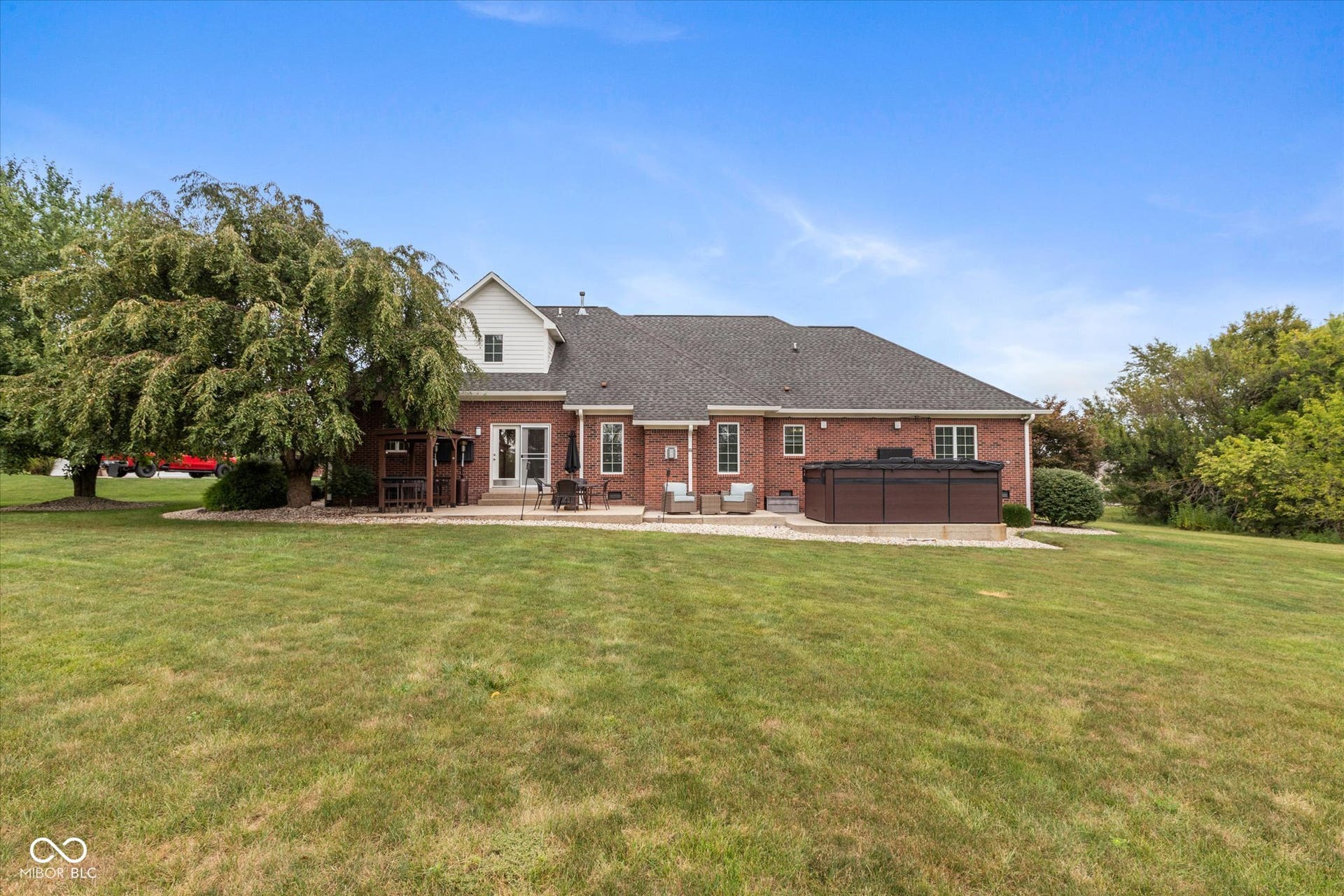 1513 Tottenham, Danville, IN 46122 Brick exterior with white trim, a dark shingle roof, and multiple exterior doors