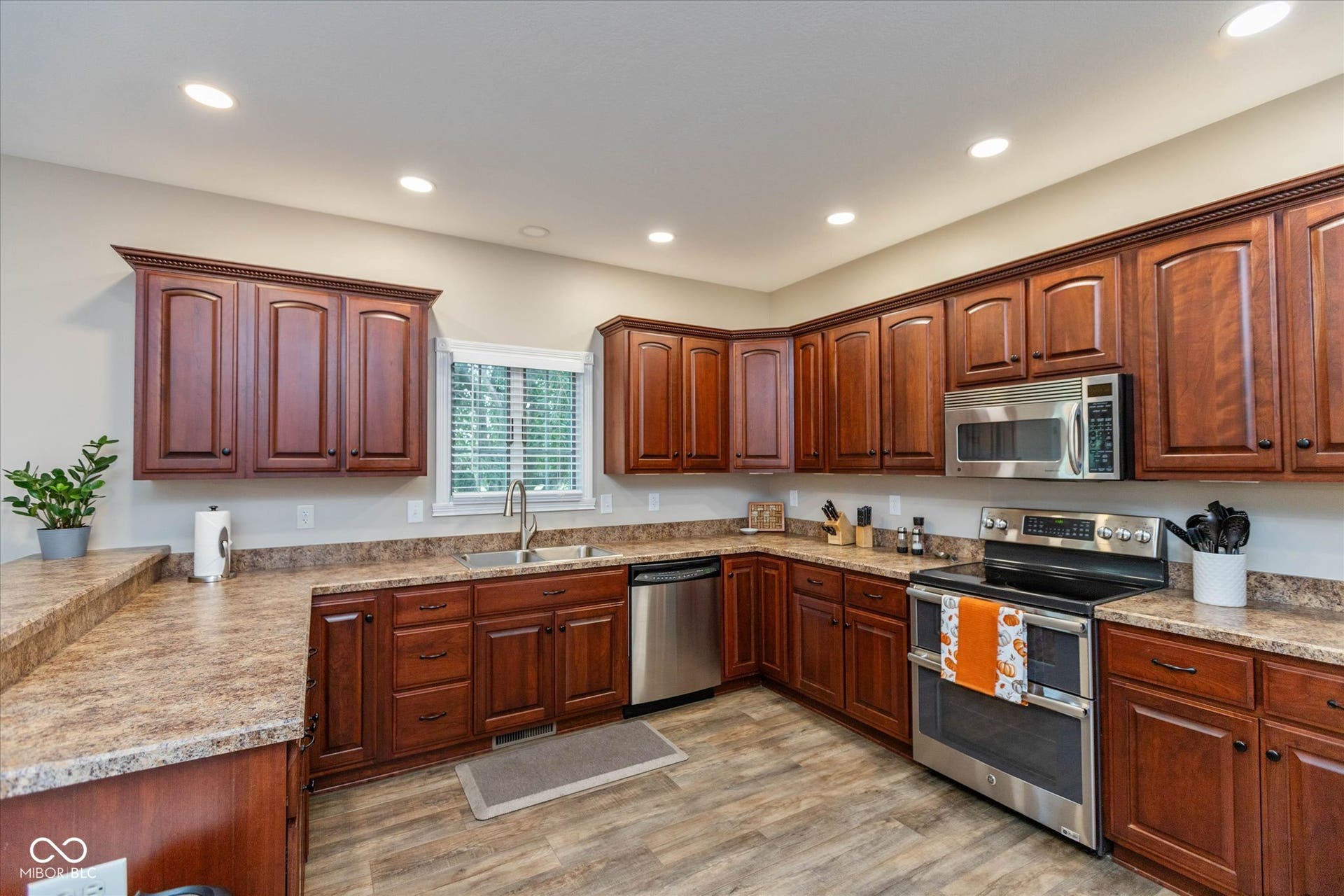 1513 Tottenham, Danville, IN 46122 Kitchen featuring wood-finish cabinetry, stainless steel appliances, laminate countertops, and wood-finish flooring