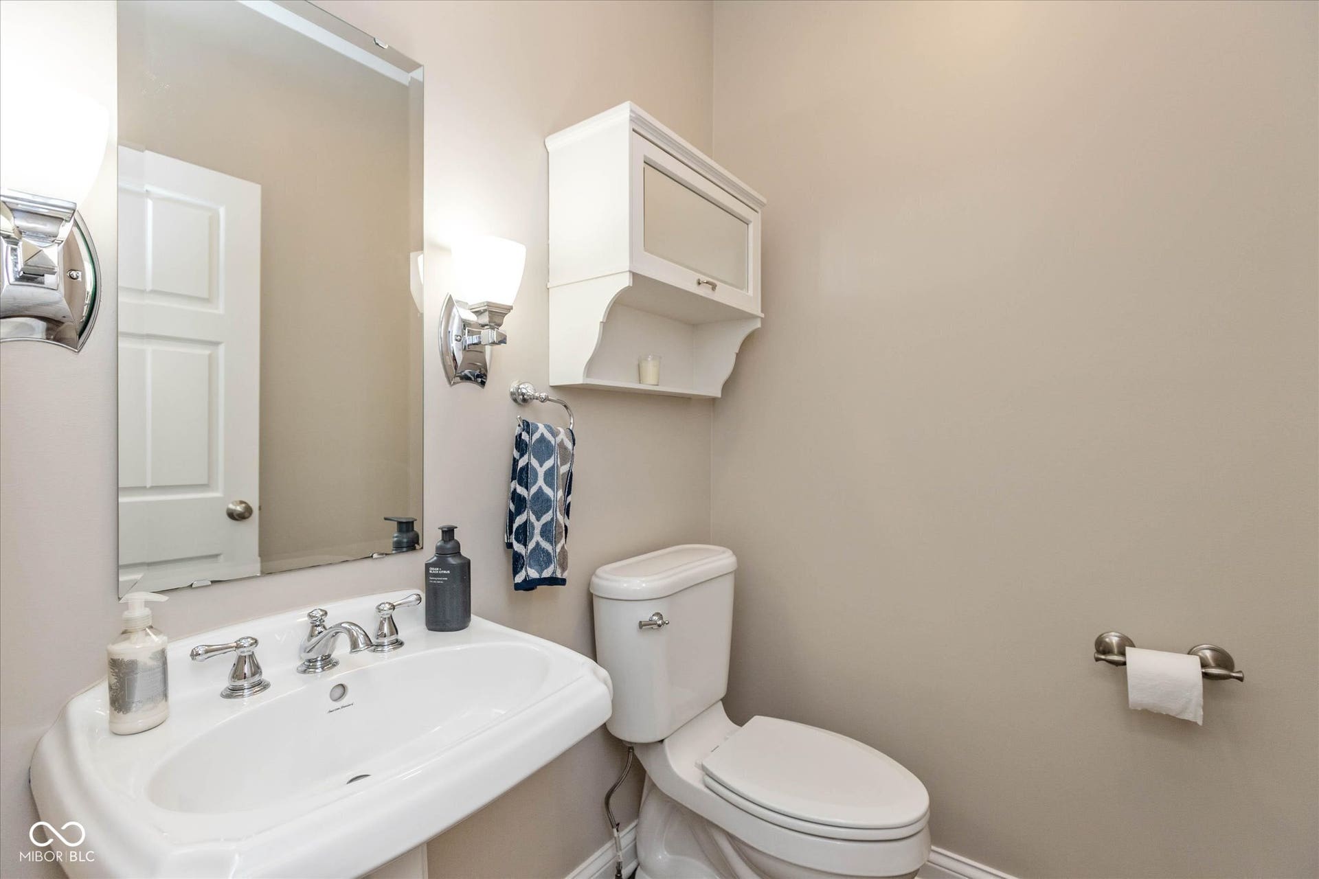 1513 Tottenham, Danville, IN 46122 Pedestal sink with chrome faucet, wall-mounted mirror, and white storage cabinet