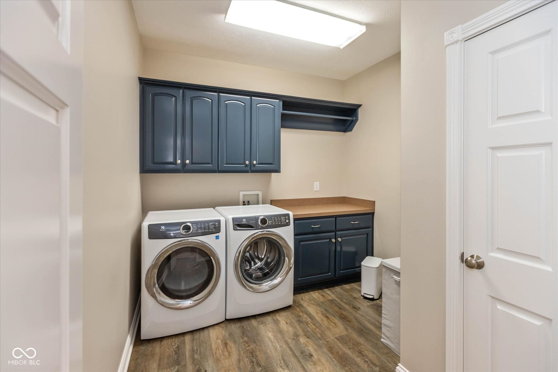 1513 Tottenham, Danville, IN 46122 Laundry area with wood-finish flooring, built-in navy cabinetry, and a countertop work surface