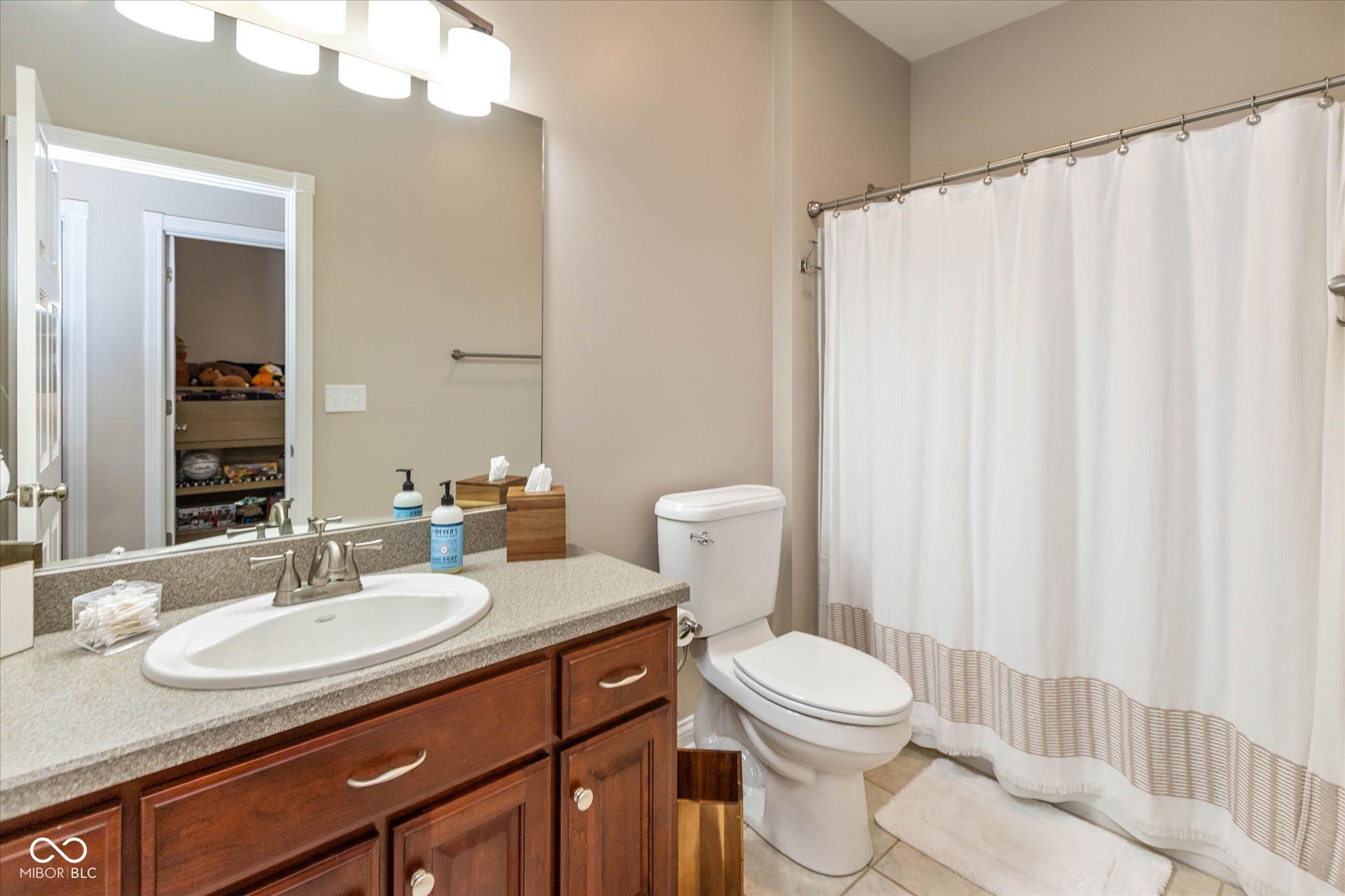 1513 Tottenham, Danville, IN 46122 Vanity with wood-finish cabinetry, a single basin sink, and a speckled countertop