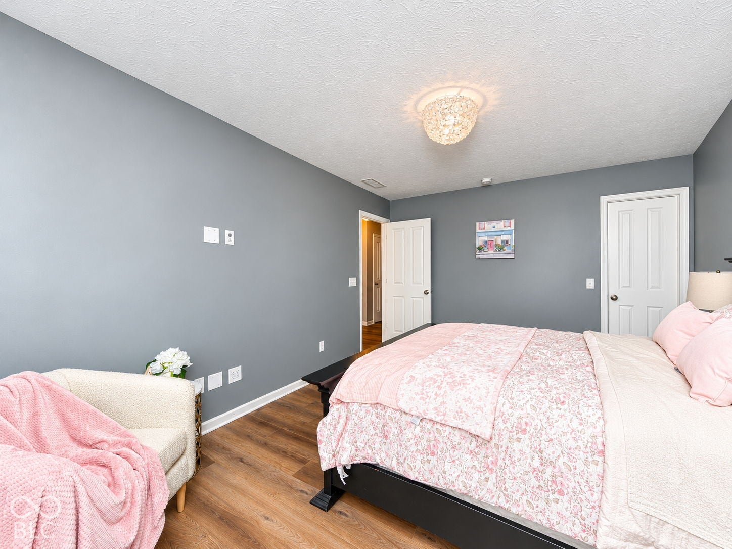 Wood-finish flooring, neutral gray walls, and a white textured ceiling