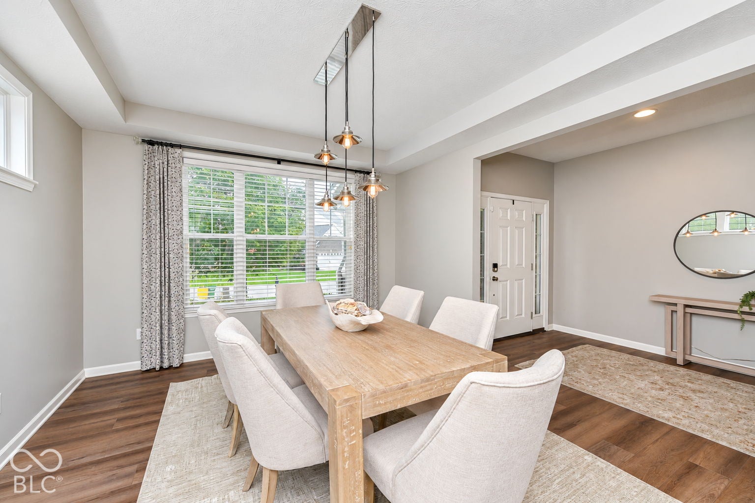 Wood-finish flooring, recessed lighting, and a multi-light pendant fixture