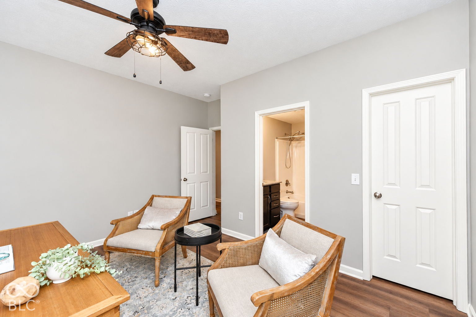Wood-finish flooring, white paneled doors, ceiling fan with integrated lighting, and a neutral wall color
