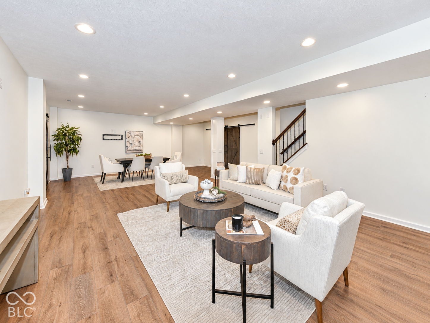 Recessed lighting illuminates the open-concept living space with wood-finish flooring