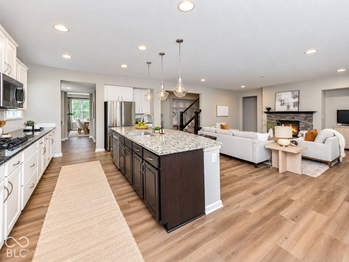 Kitchen featuring white upper and lower cabinetry, a stainless steel gas range, and a large central island with a stone countertop