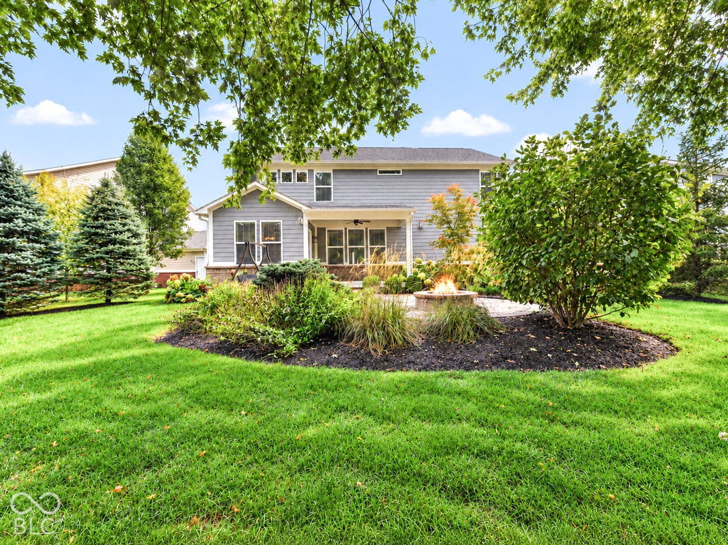 Rear exterior with light gray siding, stone accent base, and white trim