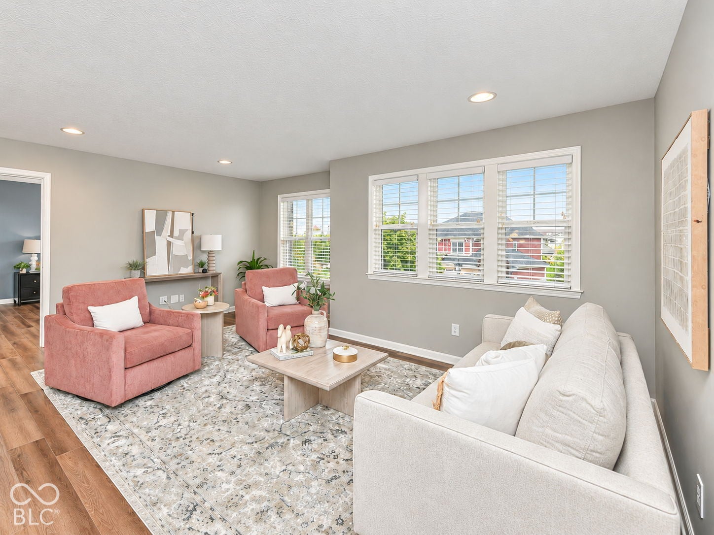 Wood-finish flooring, recessed ceiling lighting, light gray wall paint, and multiple windows with blinds