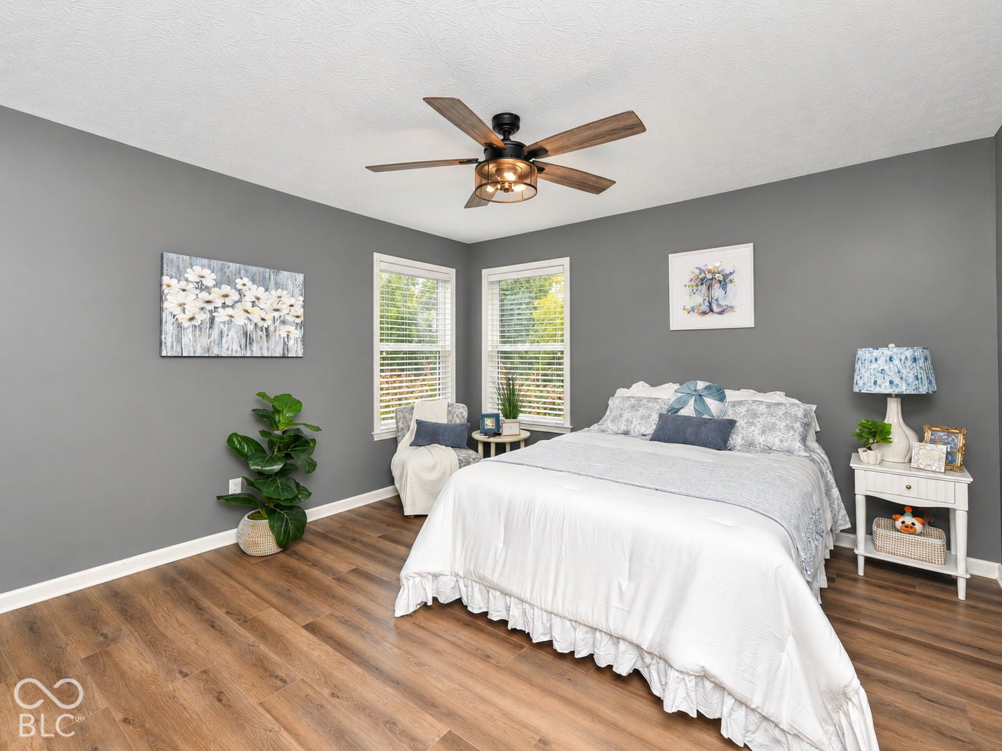 Wood-finish flooring, recessed windows with blinds, a ceiling fan with integrated lighting, and painted walls