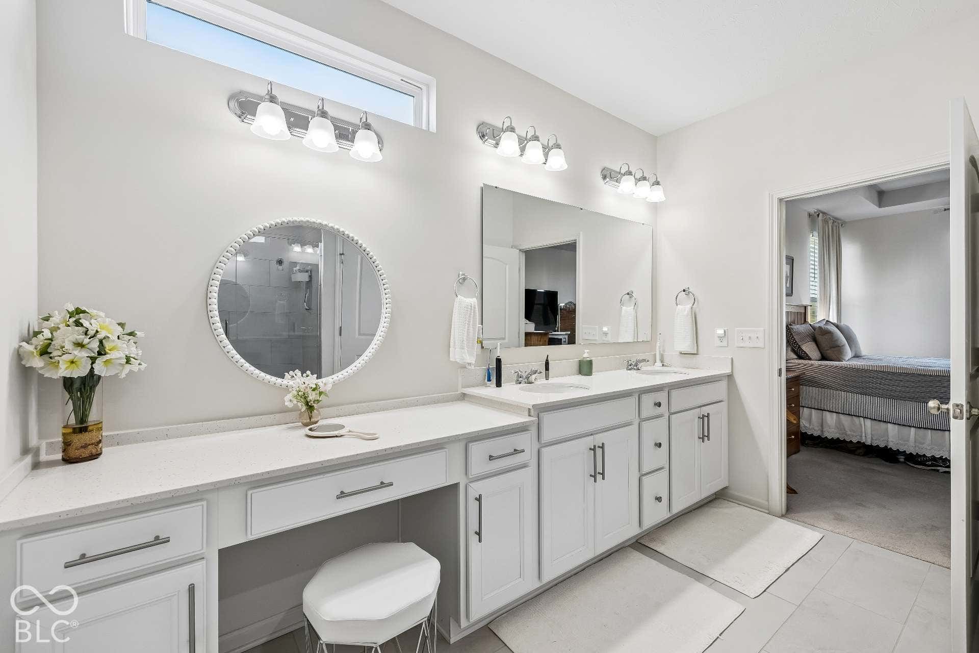 Double vanity with integrated sinks, white cabinetry, and light-toned countertops