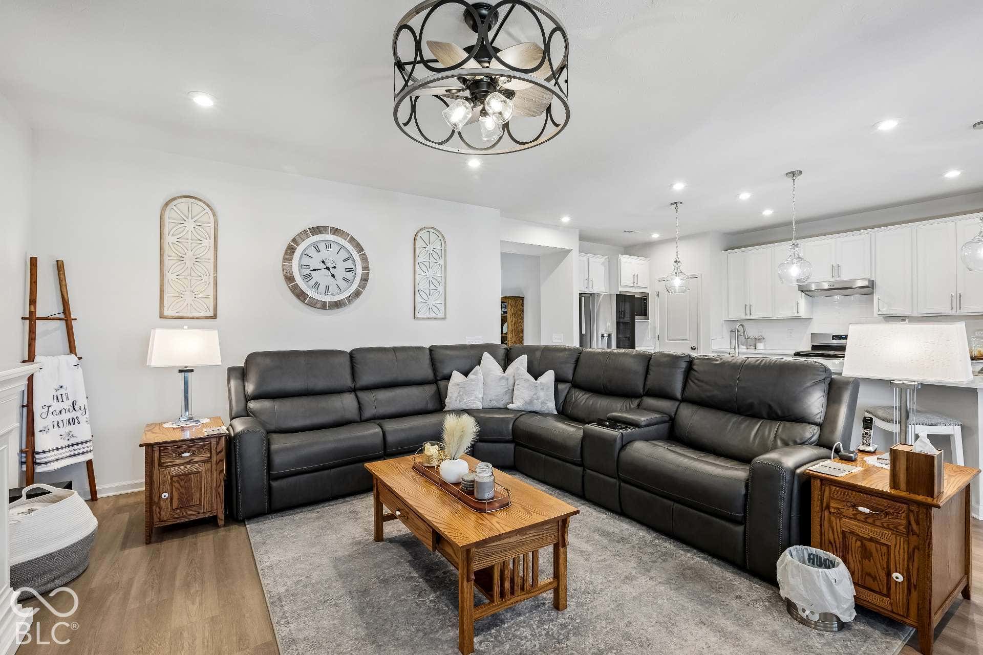 Open-concept living area featuring wood-finish flooring, recessed lighting, and a decorative ceiling fan