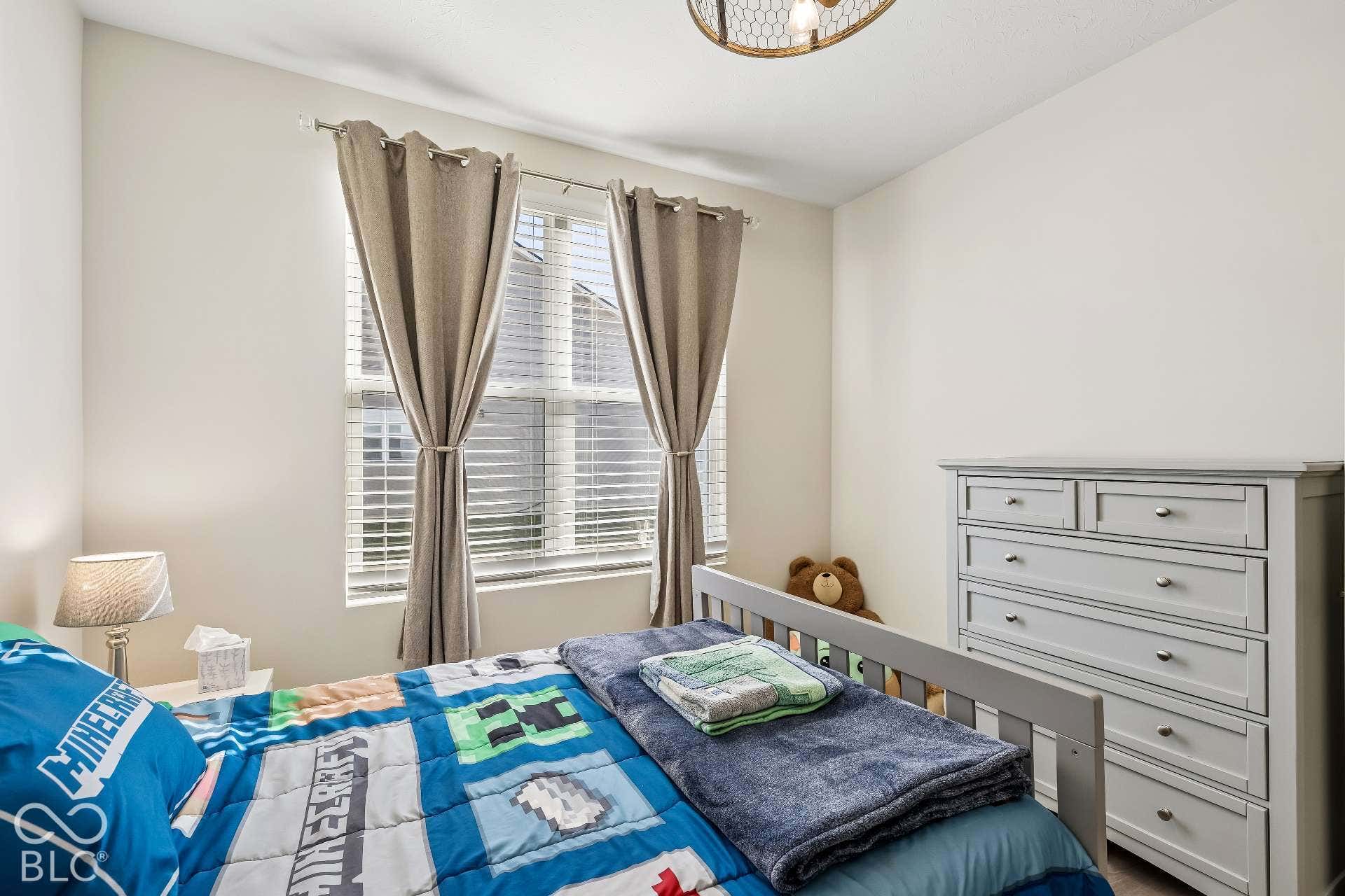 Double window with horizontal blinds, neutral wall paint, and a built-in ceiling light fixture