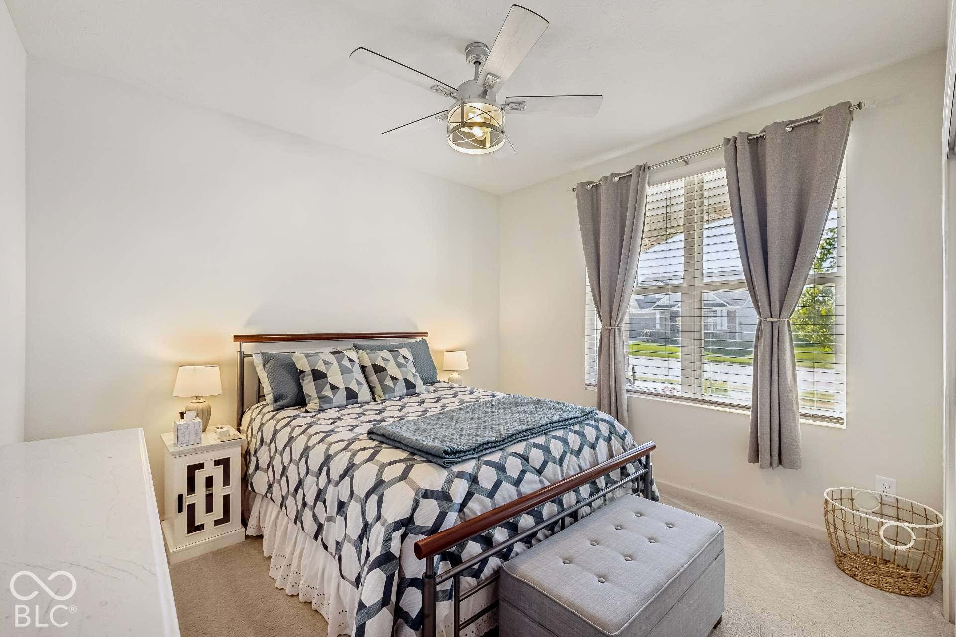 Carpeted interior space featuring a window with horizontal blinds, a ceiling fan with integrated lighting, and a white wall finish
