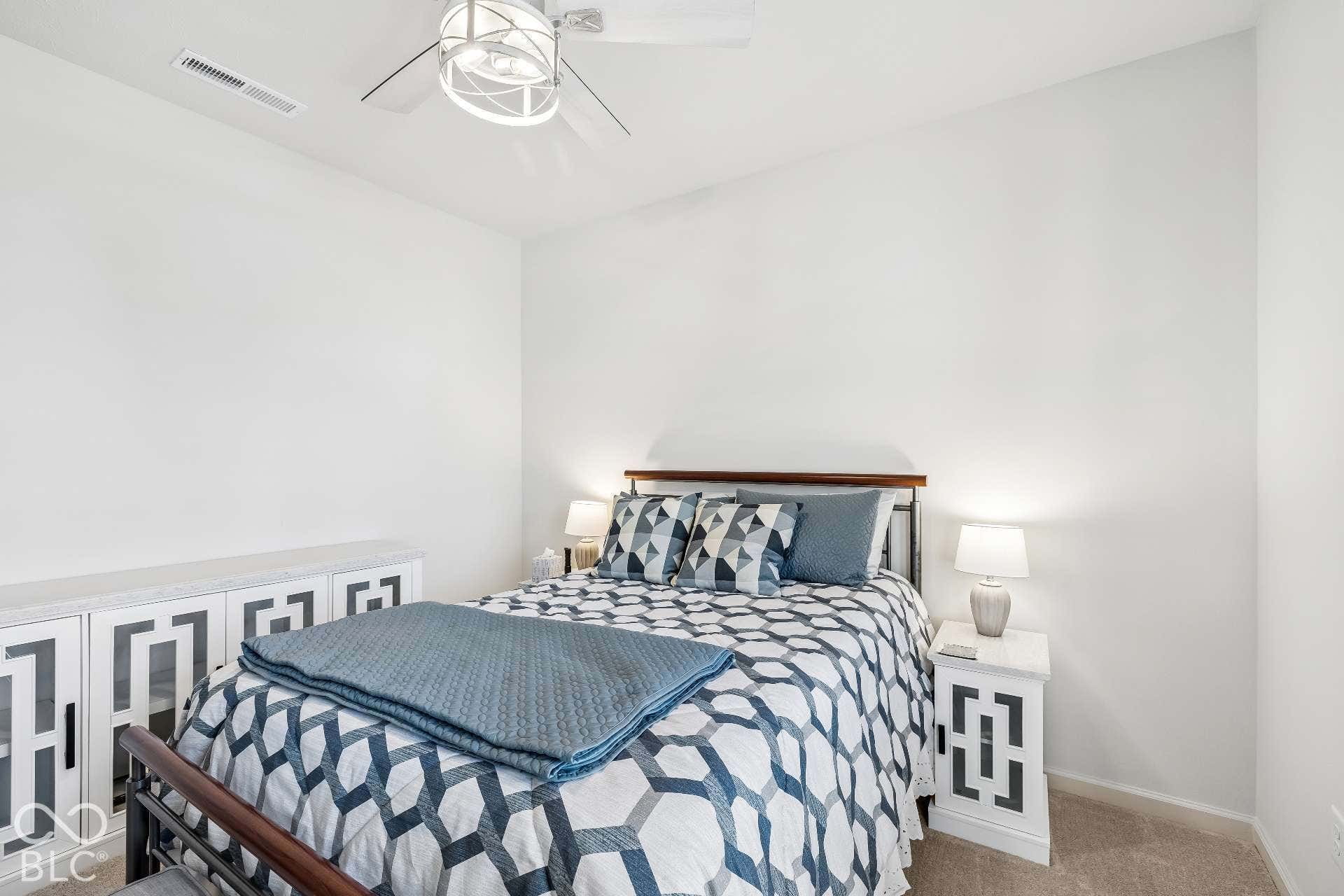 Recessed lighting and ceiling fan, built-in cabinetry with geometric paneling, and carpeted flooring