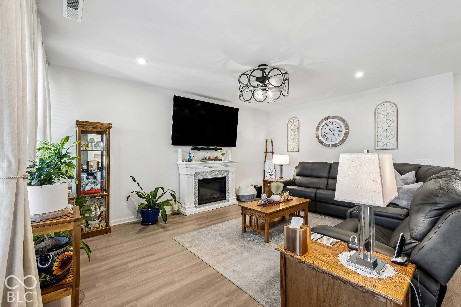 Recessed lighting illuminates the living area with wood-finish flooring