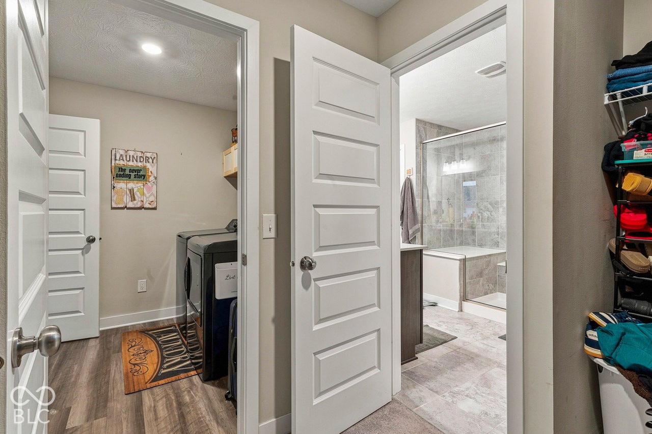 Laundry area featuring wood-finish flooring and an open shelf