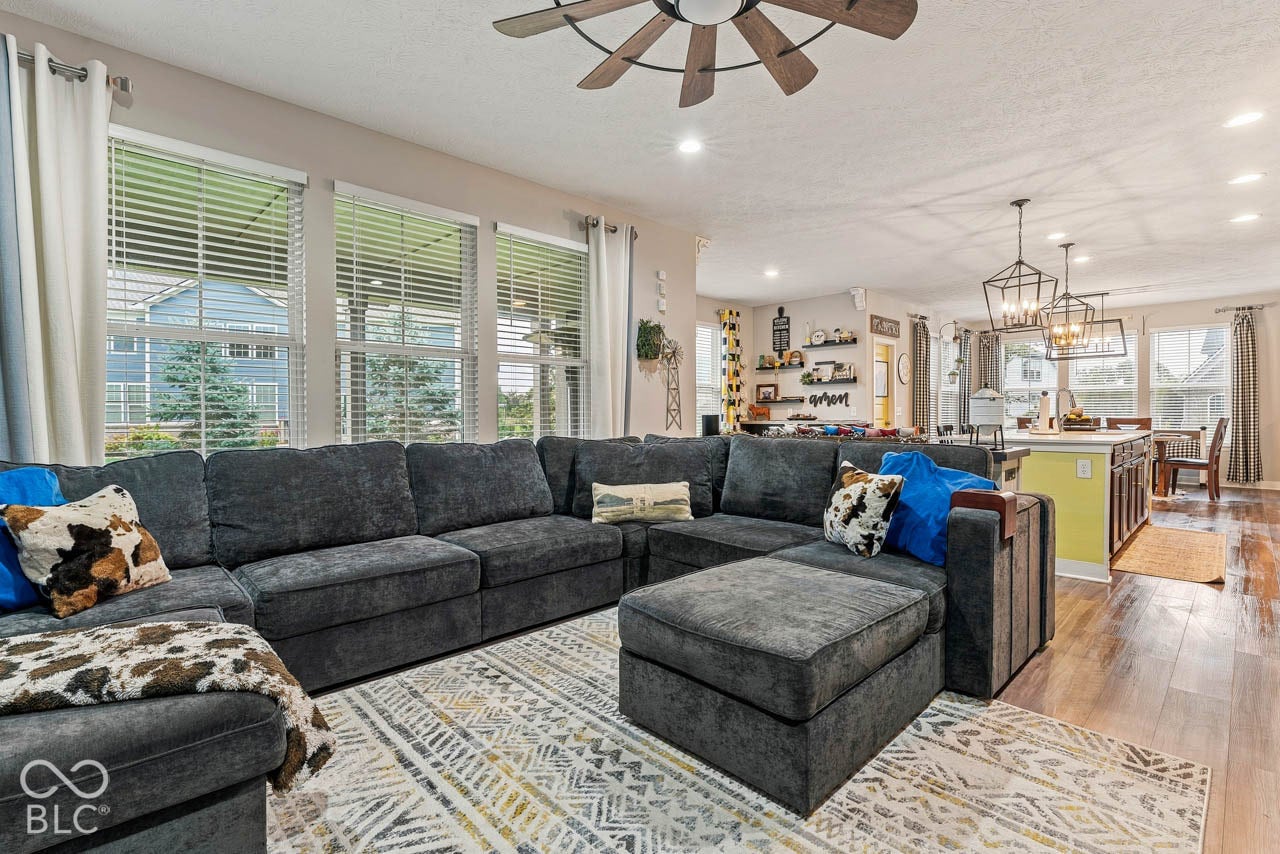 Expansive living area featuring wood-finish flooring, recessed lighting, and a ceiling fan