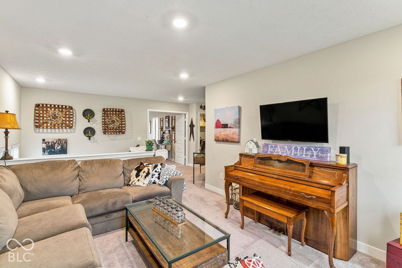 Recessed lighting illuminates this open concept living area featuring light-toned wall paint