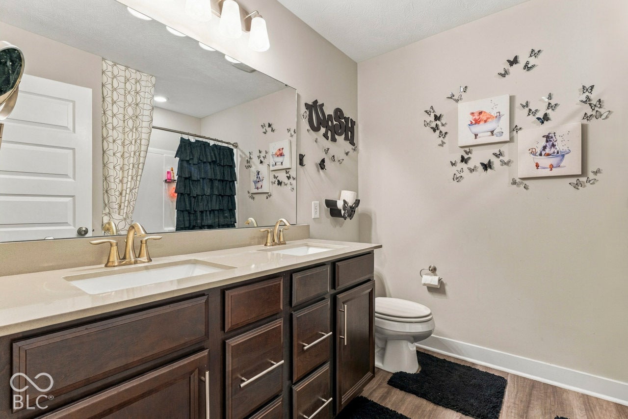 Double vanity with integrated sinks, light-toned countertop, and wood-finish cabinetry