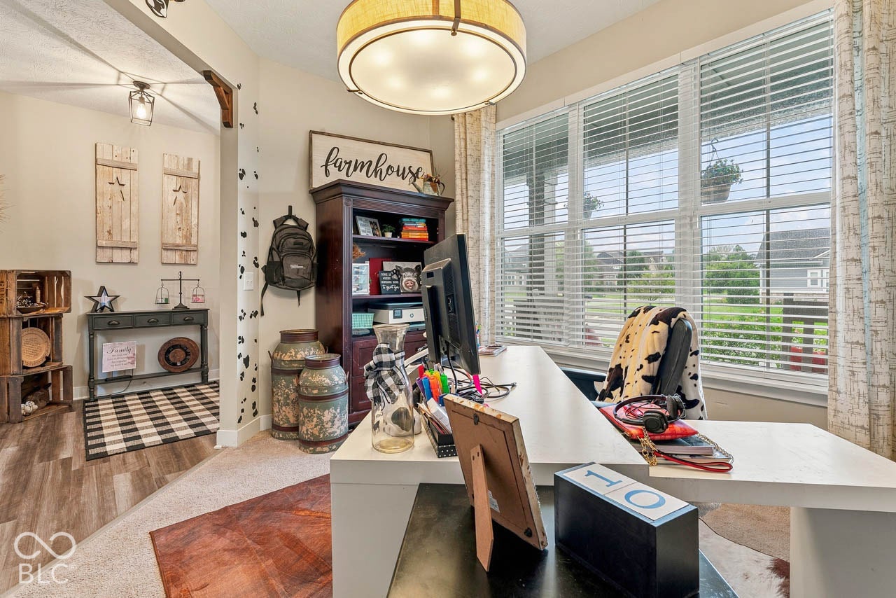 Spacious room featuring multiple windows, a wood-finish floor, and a built-in bookcase