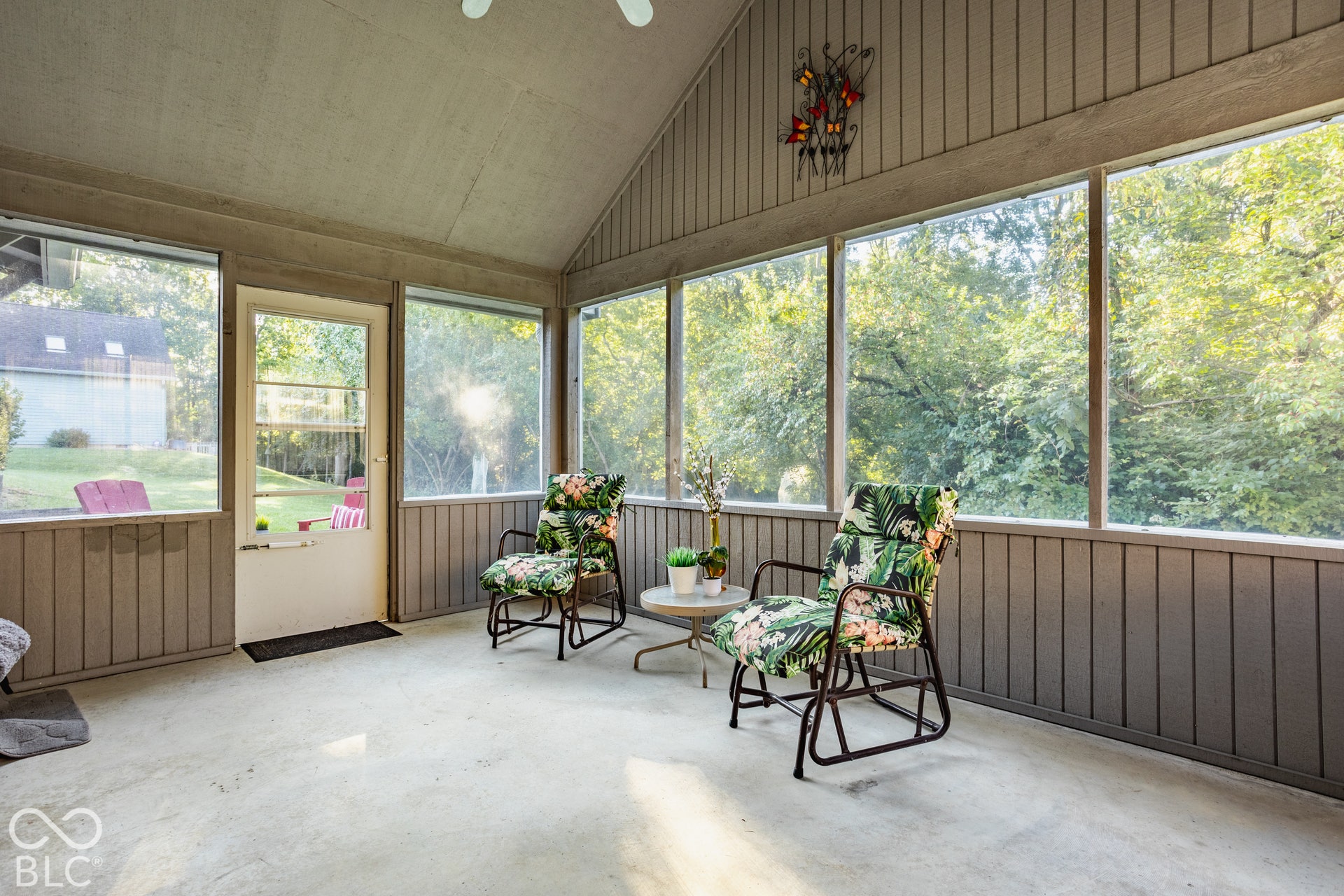 Screened porch featuring a vaulted ceiling and ceiling fan leads to the serene back yard and walk out basement.