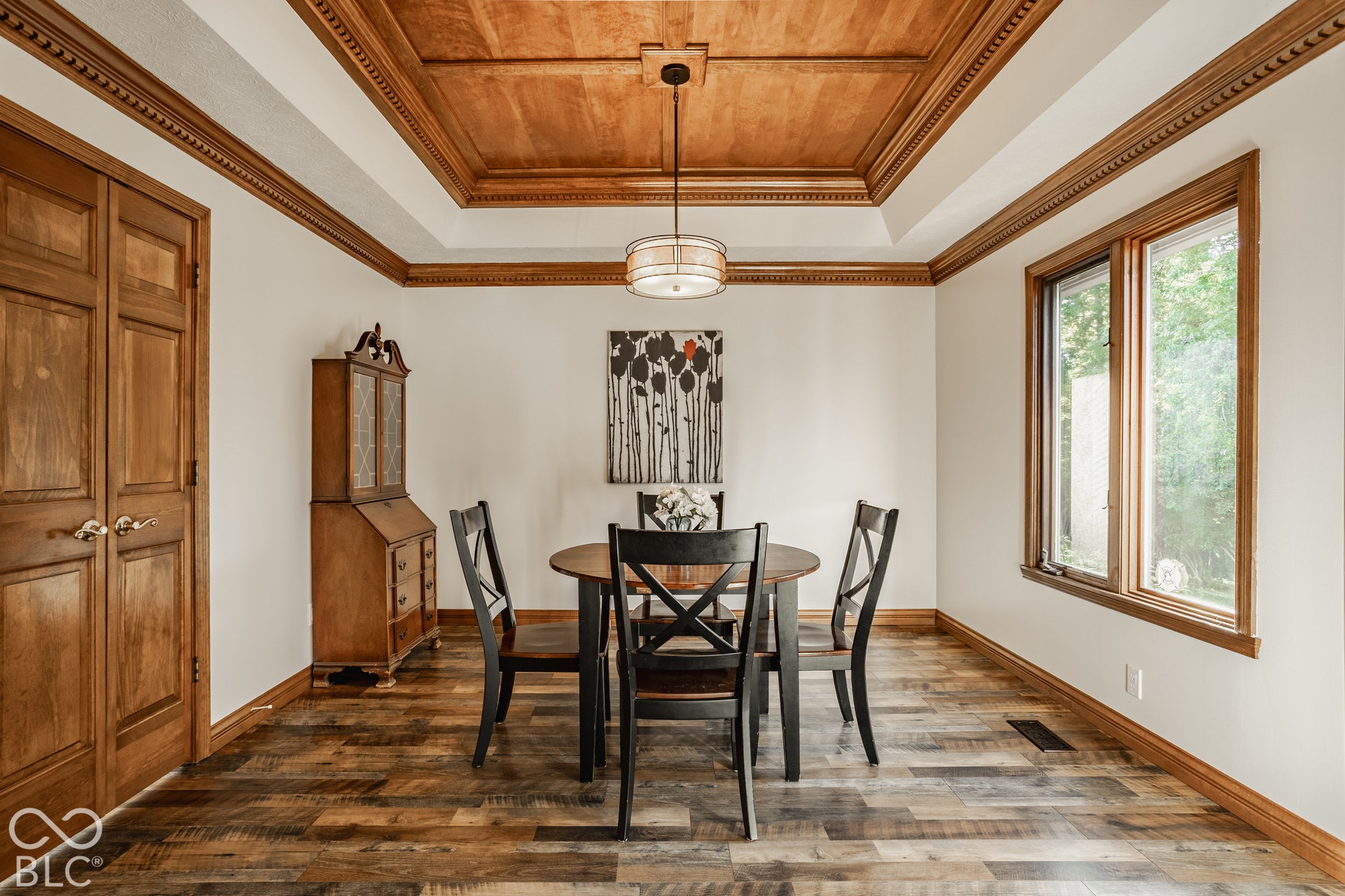 Dining room with crown molding, new LVP flooring, wood tray ceiling and solid wood trim.