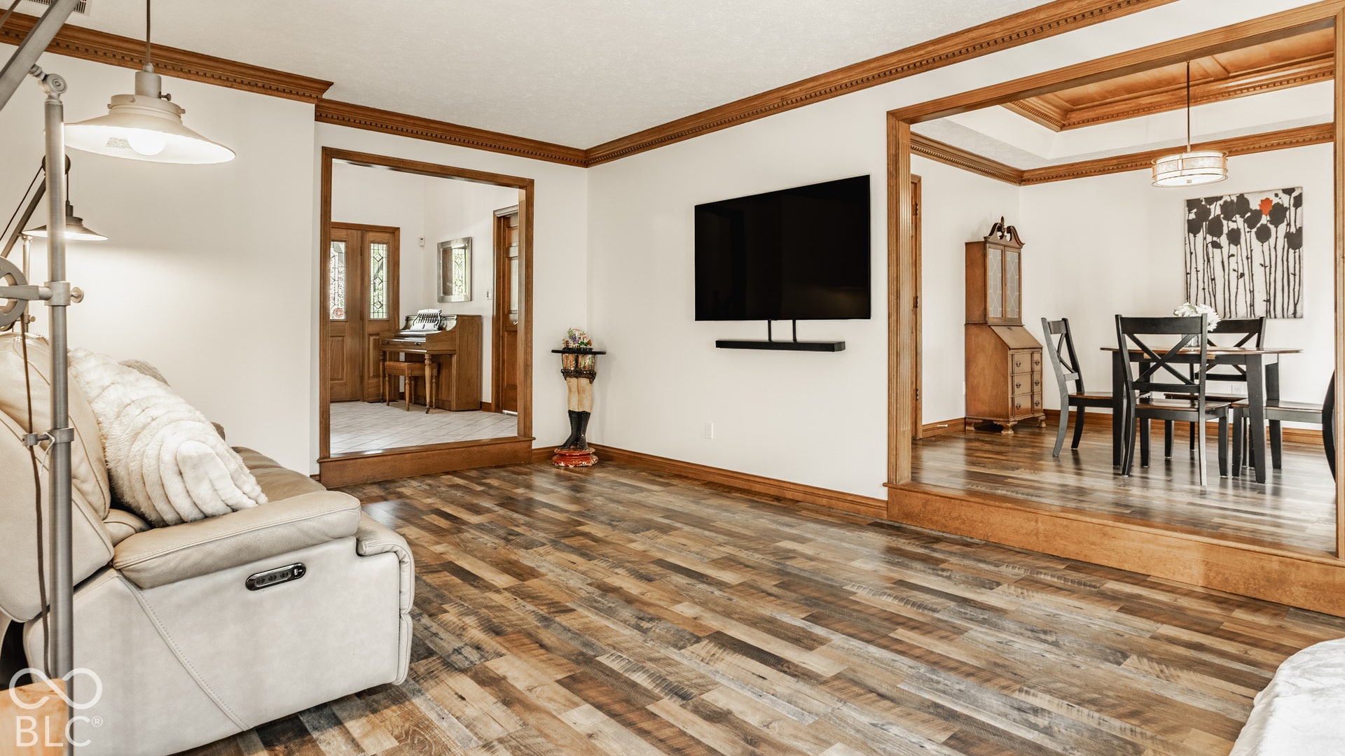 New LVP flooring throughout, with decorative wood trim and crown molding in step down living room between entry way and dining room.