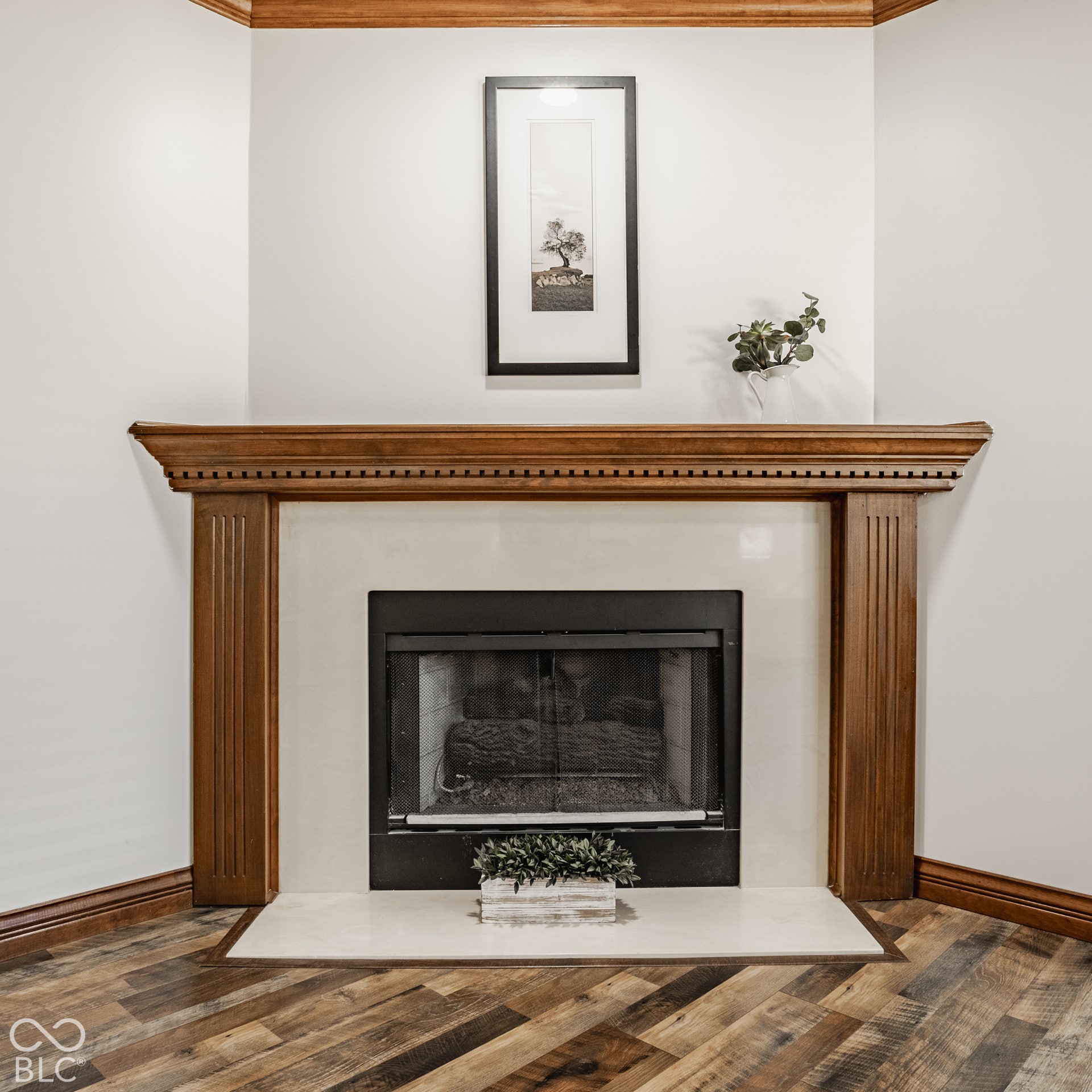 Primary Suite with gas fireplace featuring a wood mantel, new LVP flooring and expansive ensuite with wooden pocket doors.
