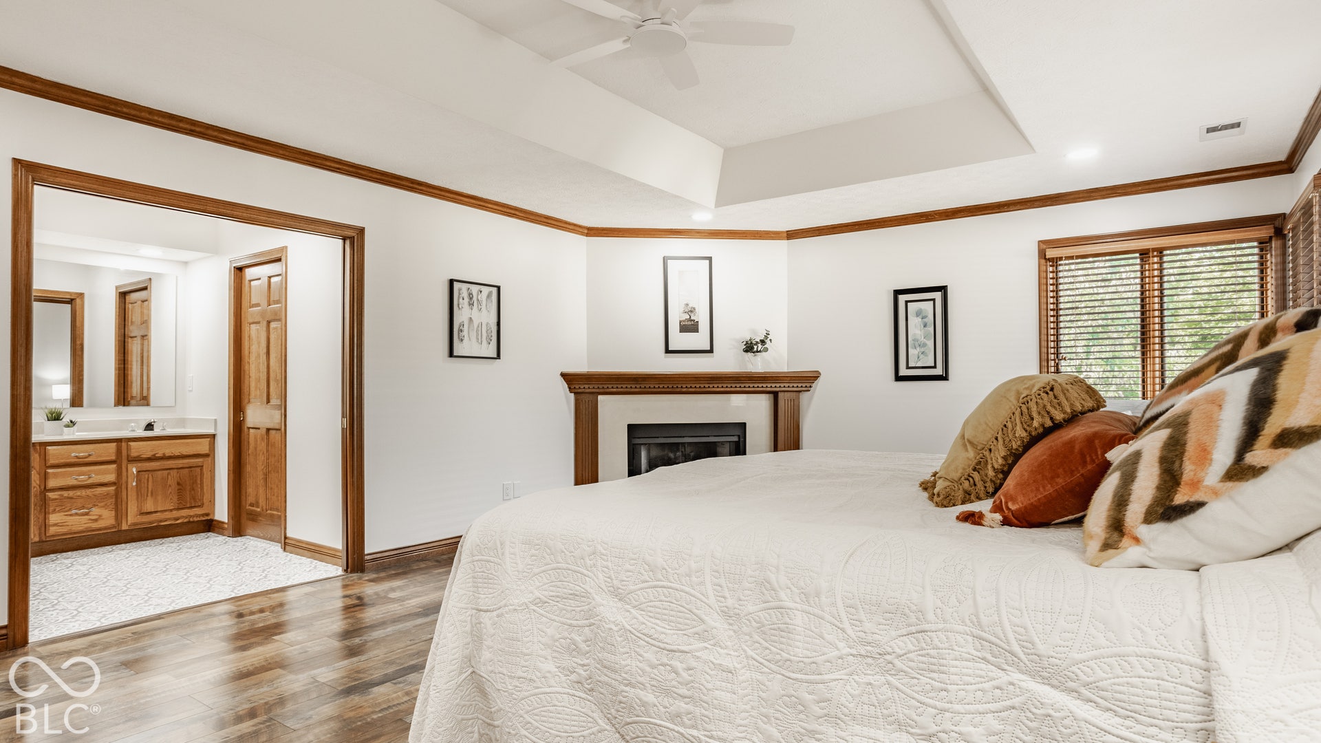 New LVP flooring throughout, tray ceiling, integrated ceiling fan, and a built-in fireplace with a wood mantle