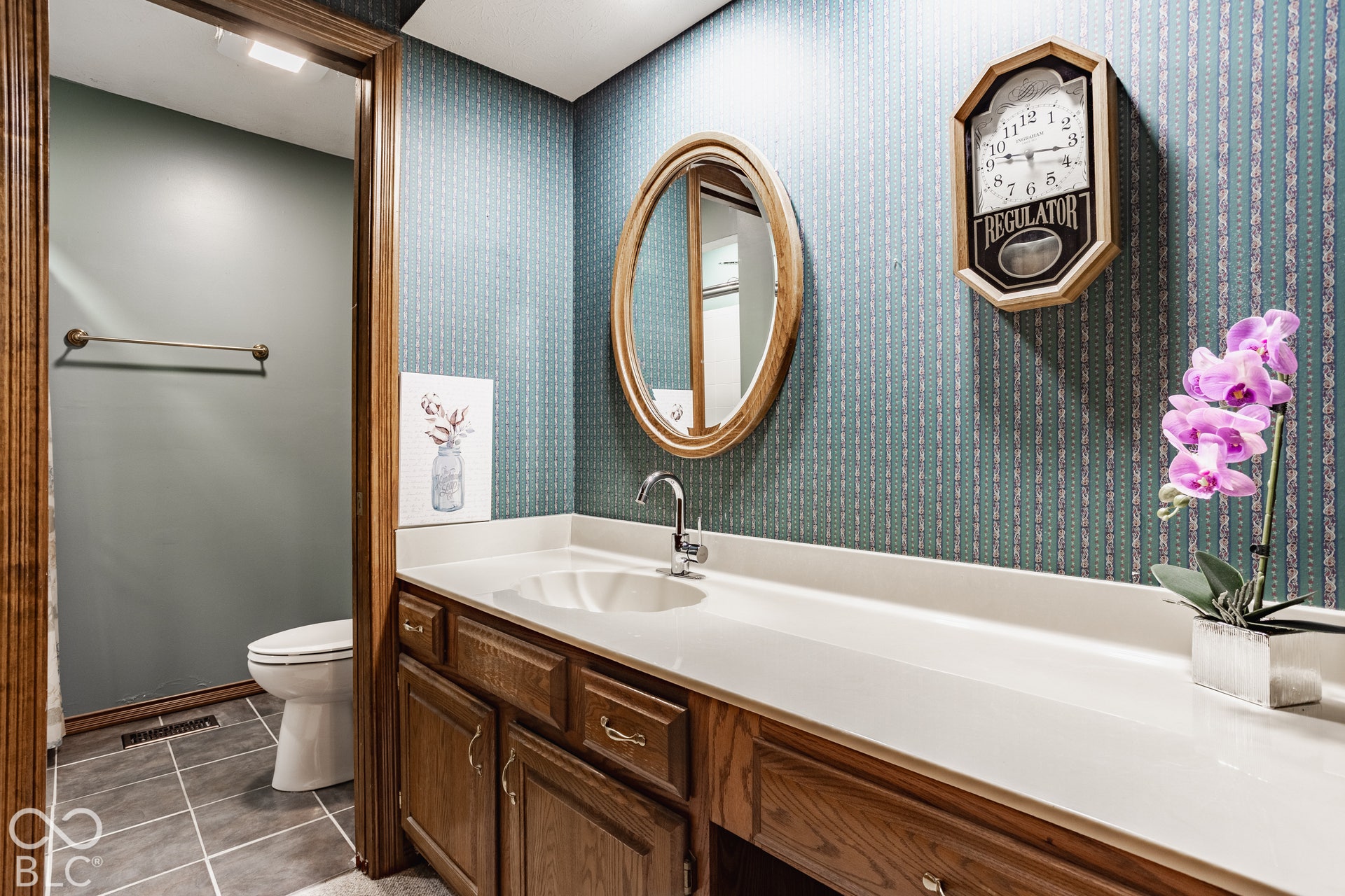 Large bathroom in basement apartment with vanity with a built-in sink, chrome faucet, and wood-finish cabinetry
