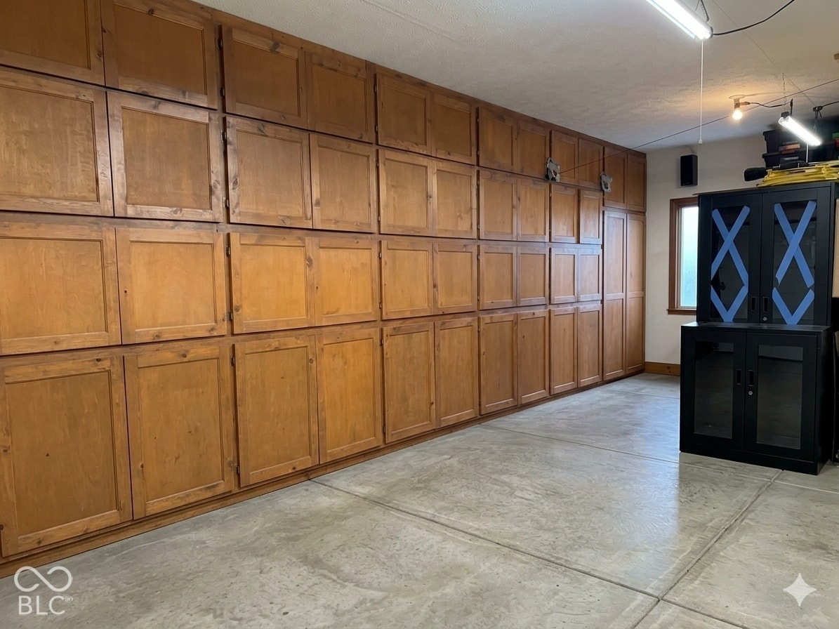 Virtually Altered - Extensive built-in wood cabinetry, concrete flooring, and plenty of space in this side load 3 car garage! Virtually altered: belongings removed.
