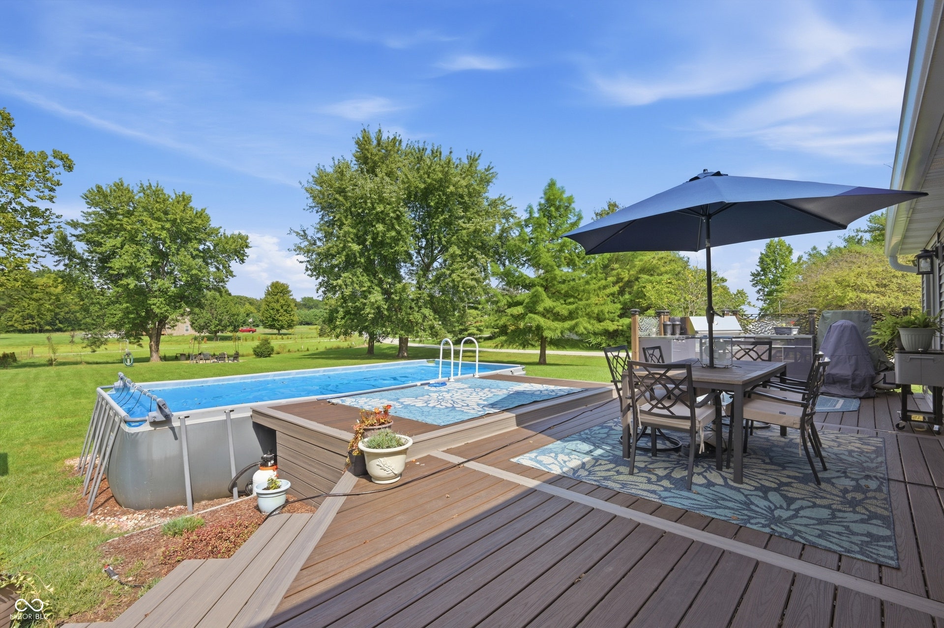 Expansive outdoor deck with an above-ground pool, providing ample space for outdoor activities