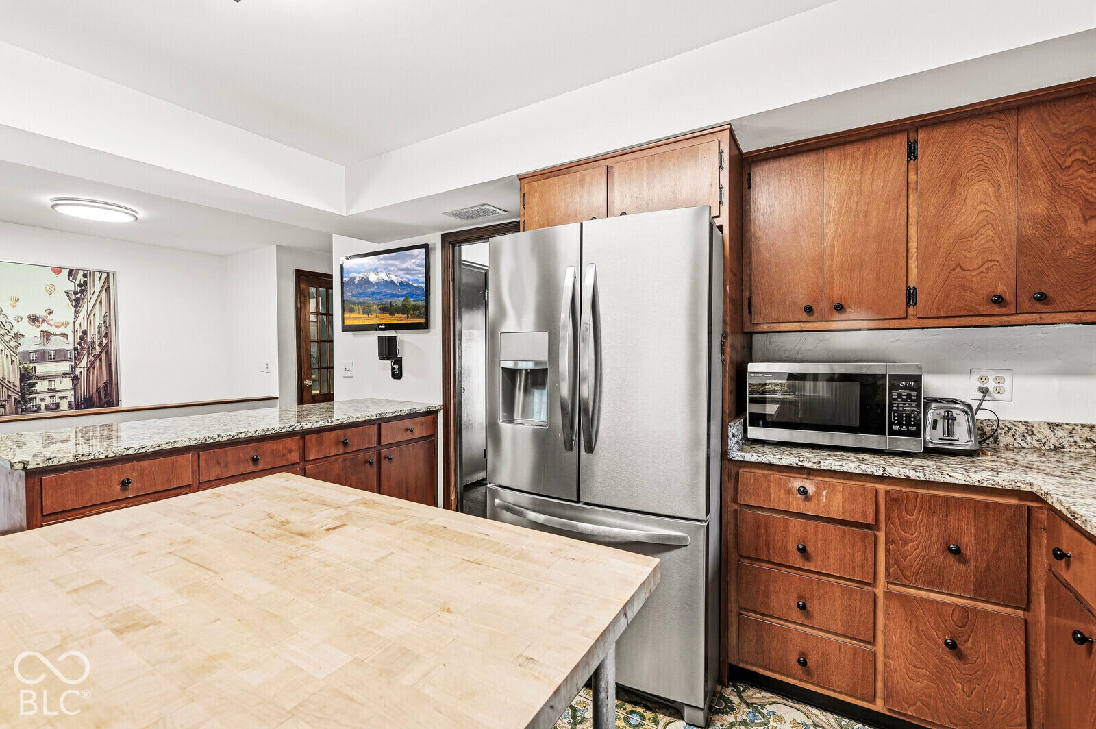 7622 Silverpine Court, Indianapolis, IN 46250 Kitchen has preserved cabinetry, BOOS island cart, and new stainless-steel appliance suite with a gas cooktop and double oven.