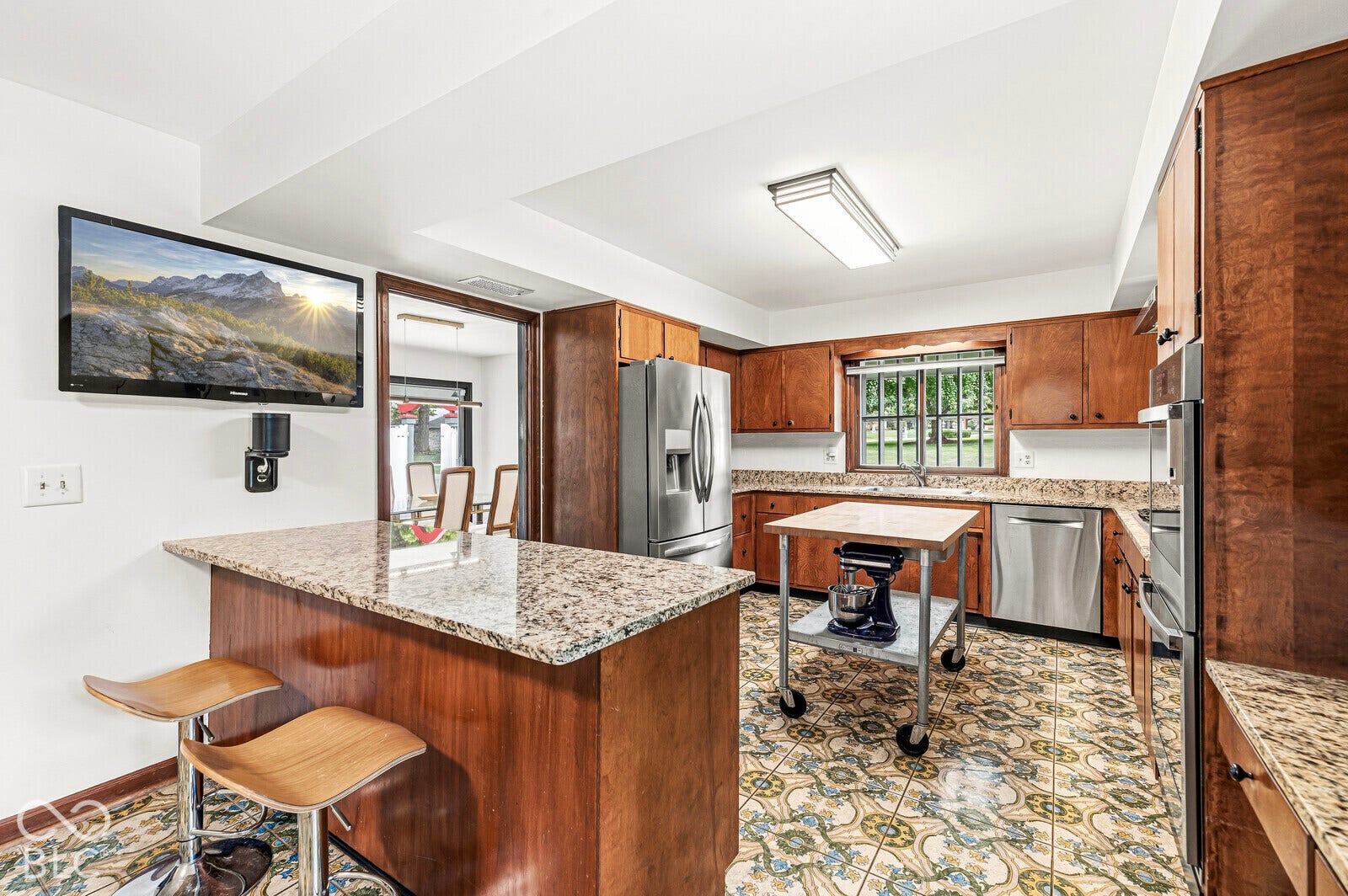 7622 Silverpine Court, Indianapolis, IN 46250 Kitchen has preserved cabinetry, BOOS island cart, and new stainless-steel appliance suite with a gas cooktop and double oven.