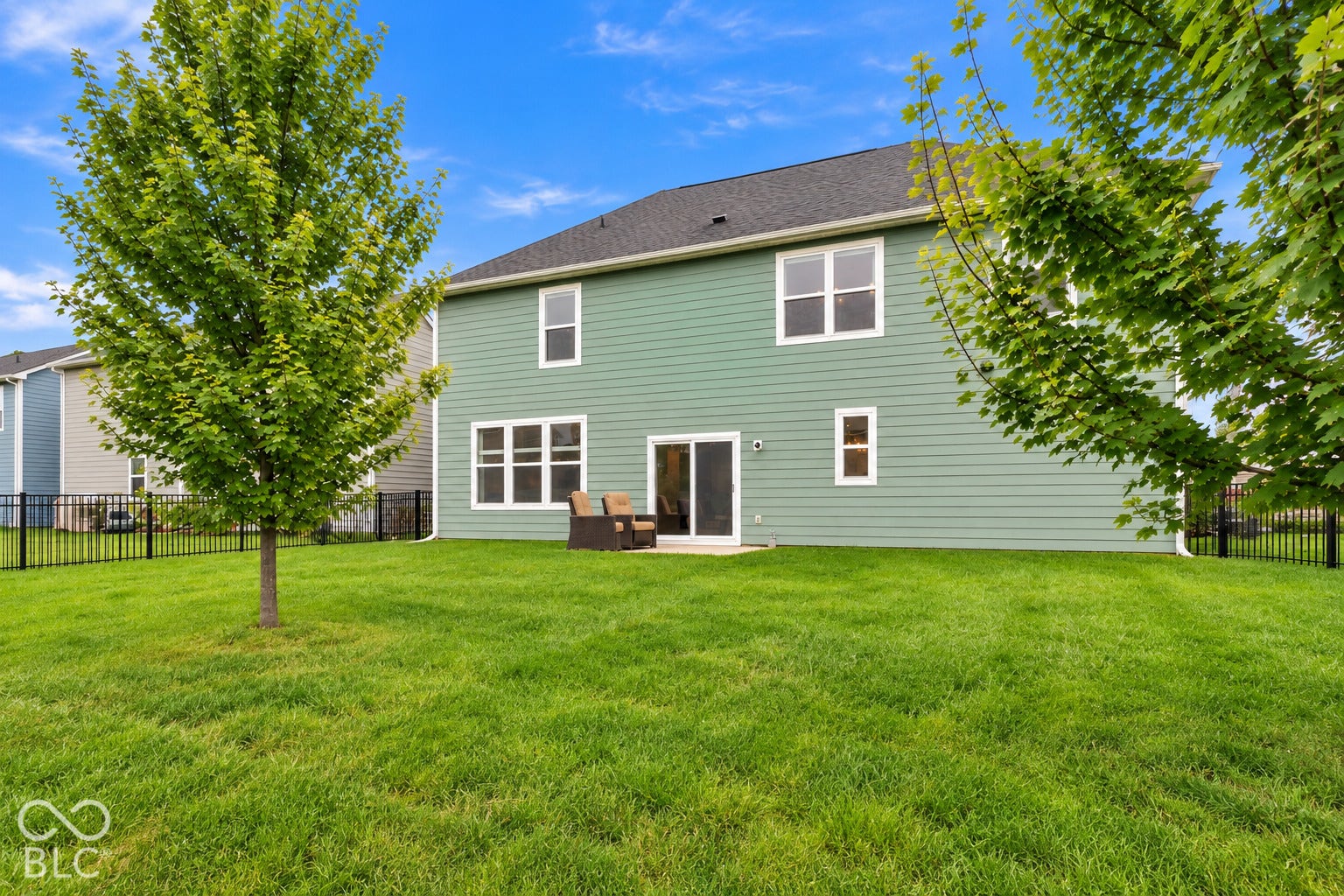 Rear Exterior with trees, fenced in backyard and patio