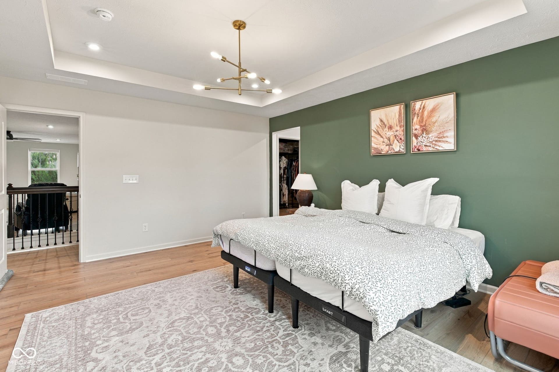 Recessed lighting, LVP flooring, tray ceiling, modern chandelier, large windows and accent wall